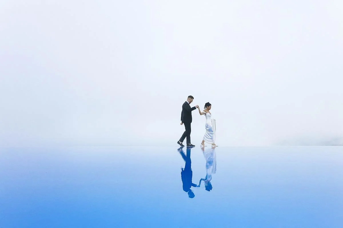 Amalfi coast wedding photographer Bride and groom walking on the edge of the infinity pool at Hotel Caruso in Ravello. Photo by Rellini art studio