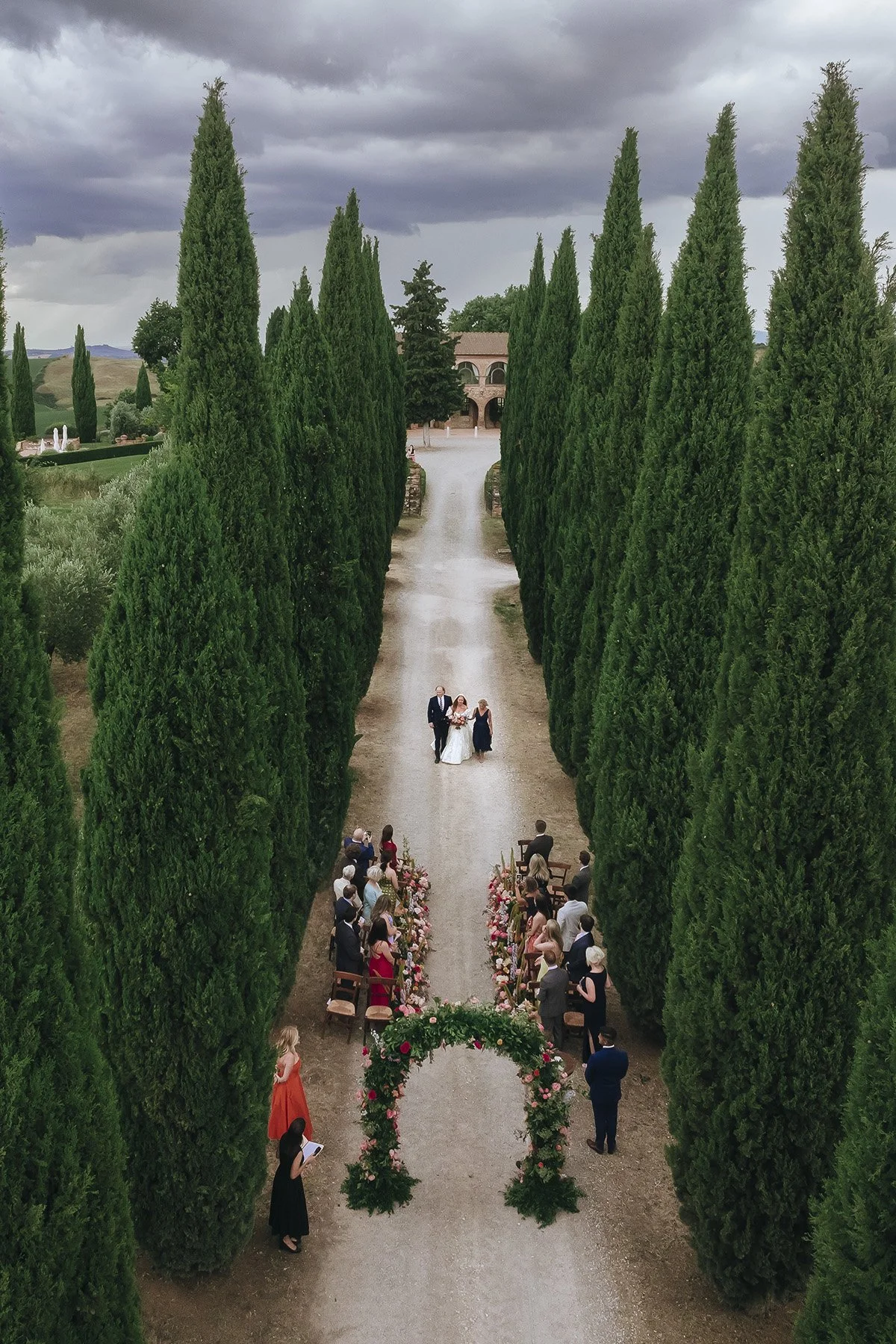 aerial view of the bride walking down the aisle at Villa Boscarello for a celebration between the cypresses