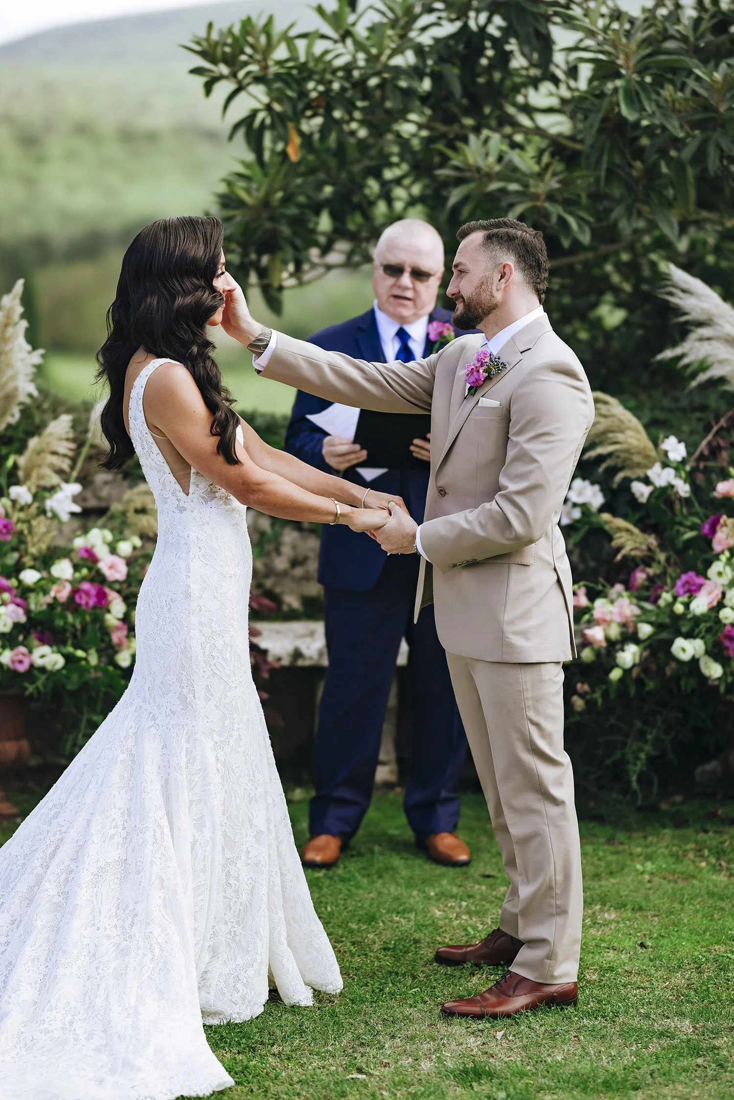 intimate moment of the ceremony  with the groom caressing the bride