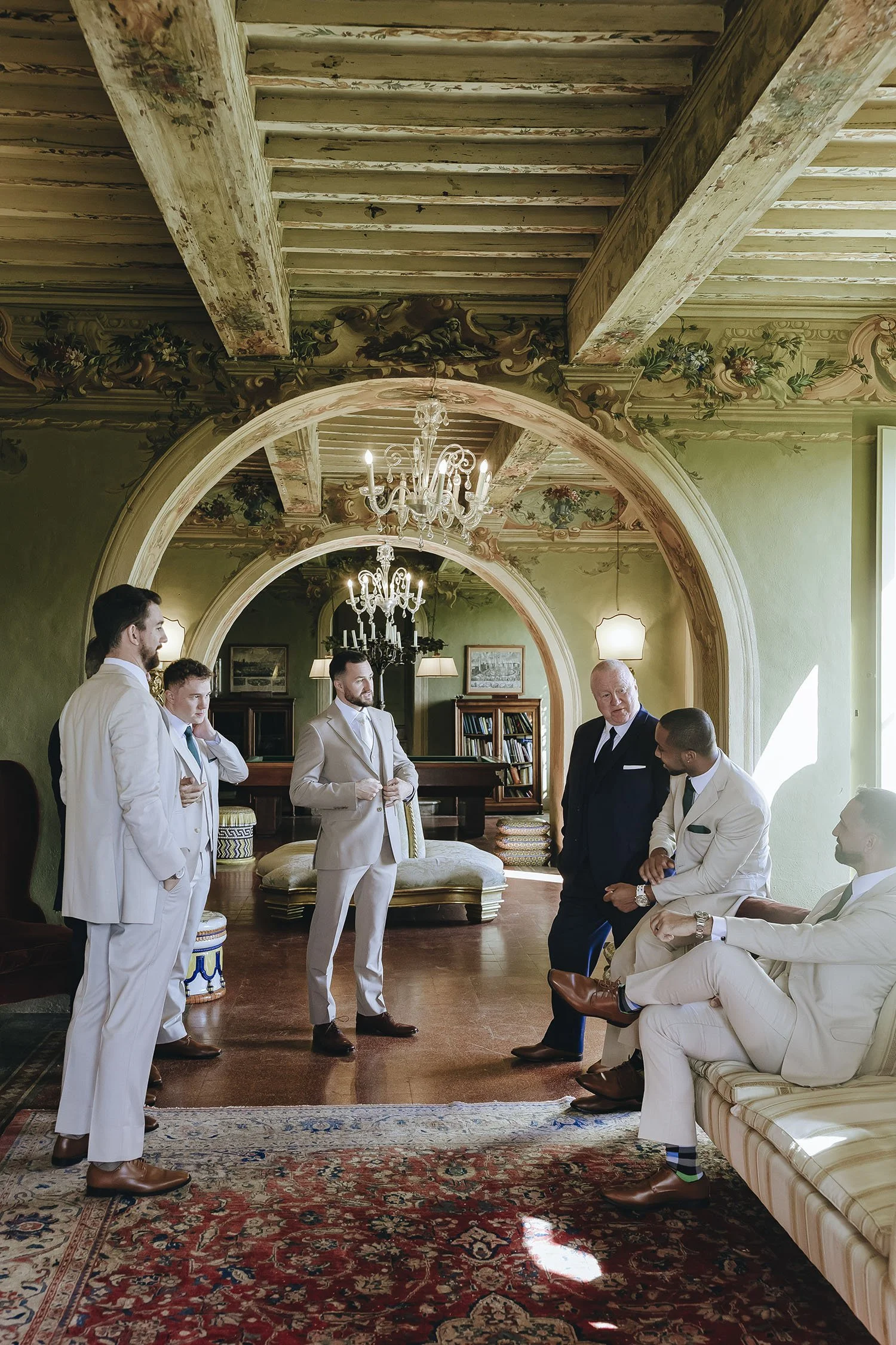 groom getting ready with groomsmen in a beautiful room at Borgo di Stomennano