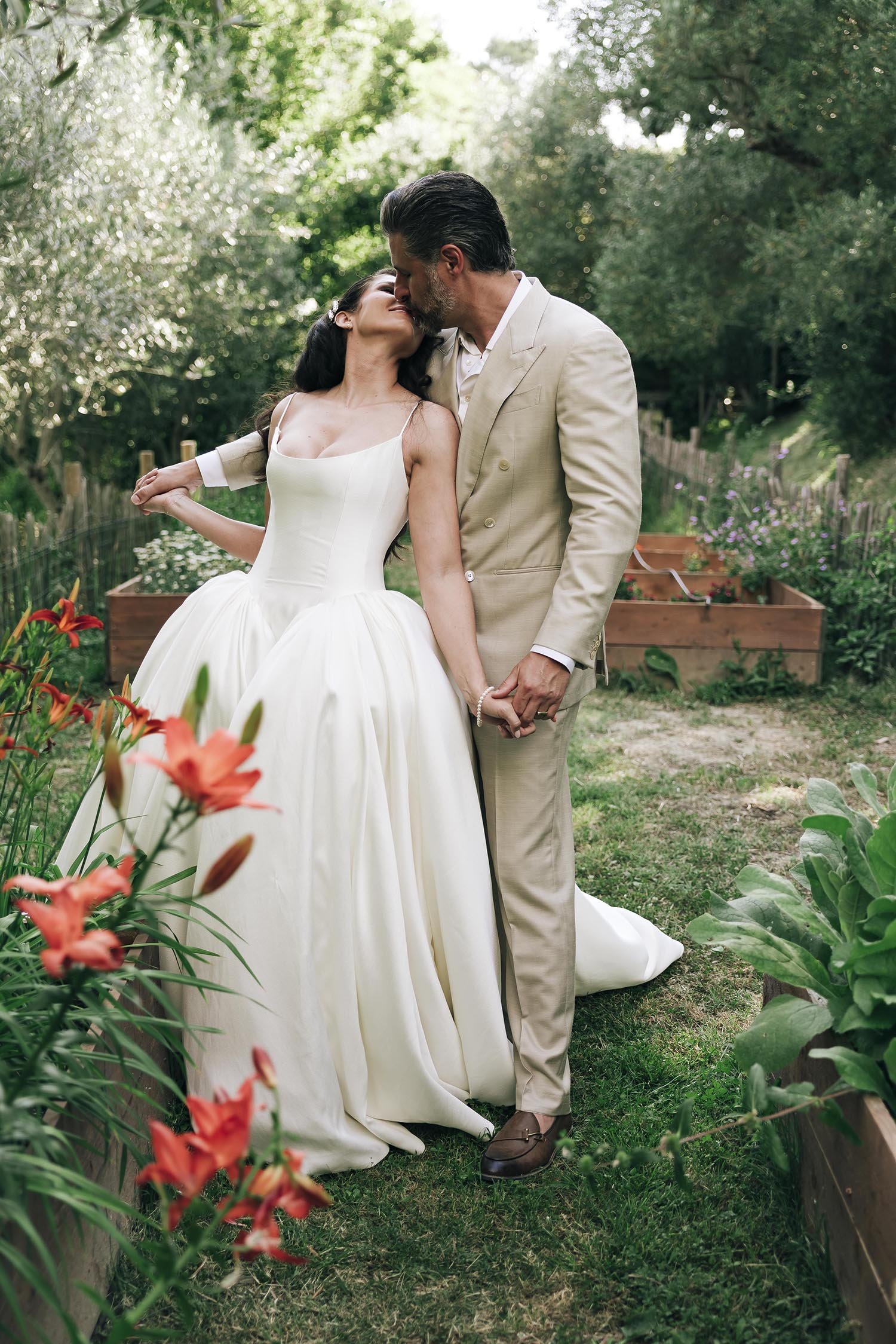 bride and groom kiss in the garden at Borgo Castello Panicaglia
