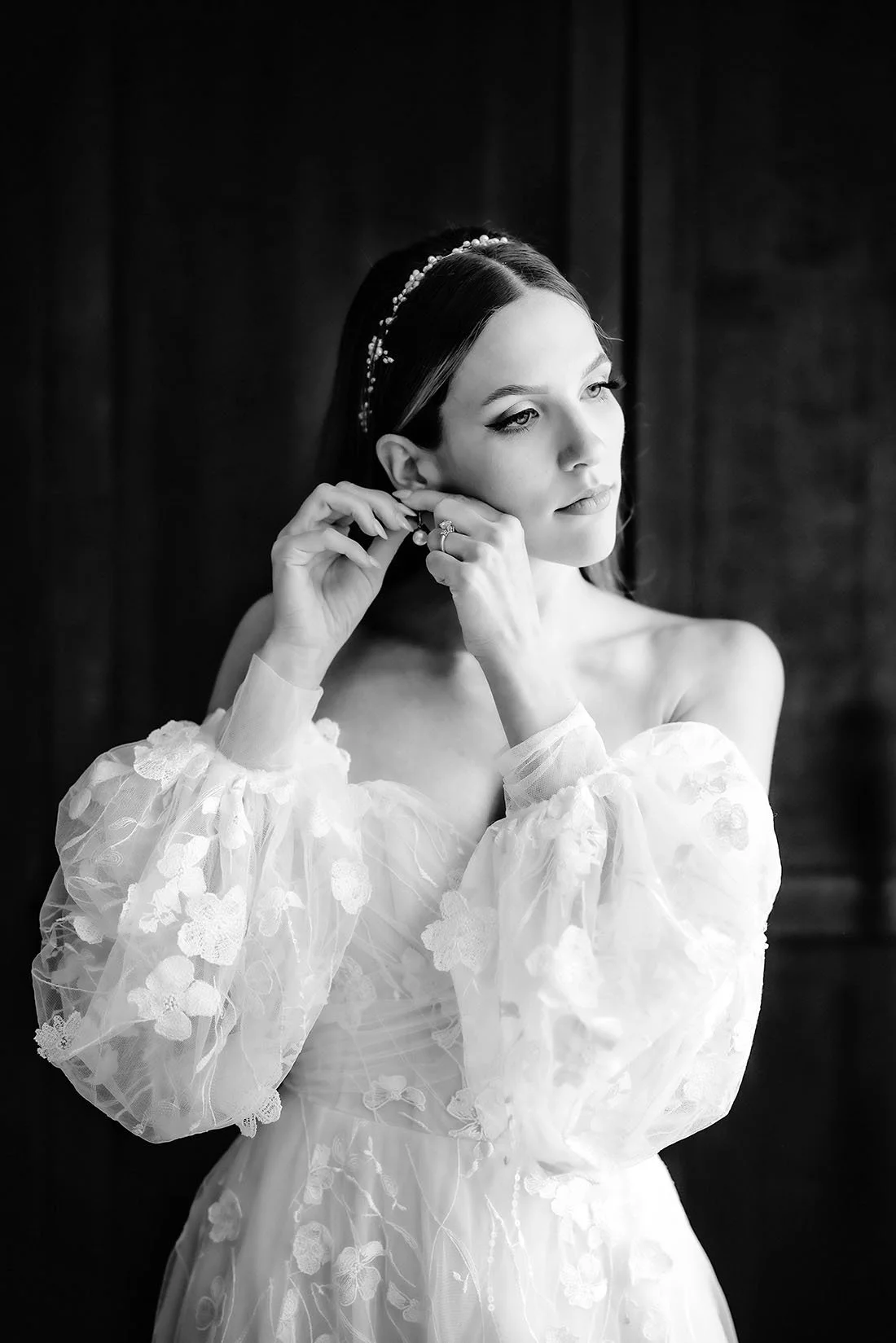 TImeless portrait of the bride putting on jewelry by the window. Photo by Rellini art studio best wedding photographers in Umbria