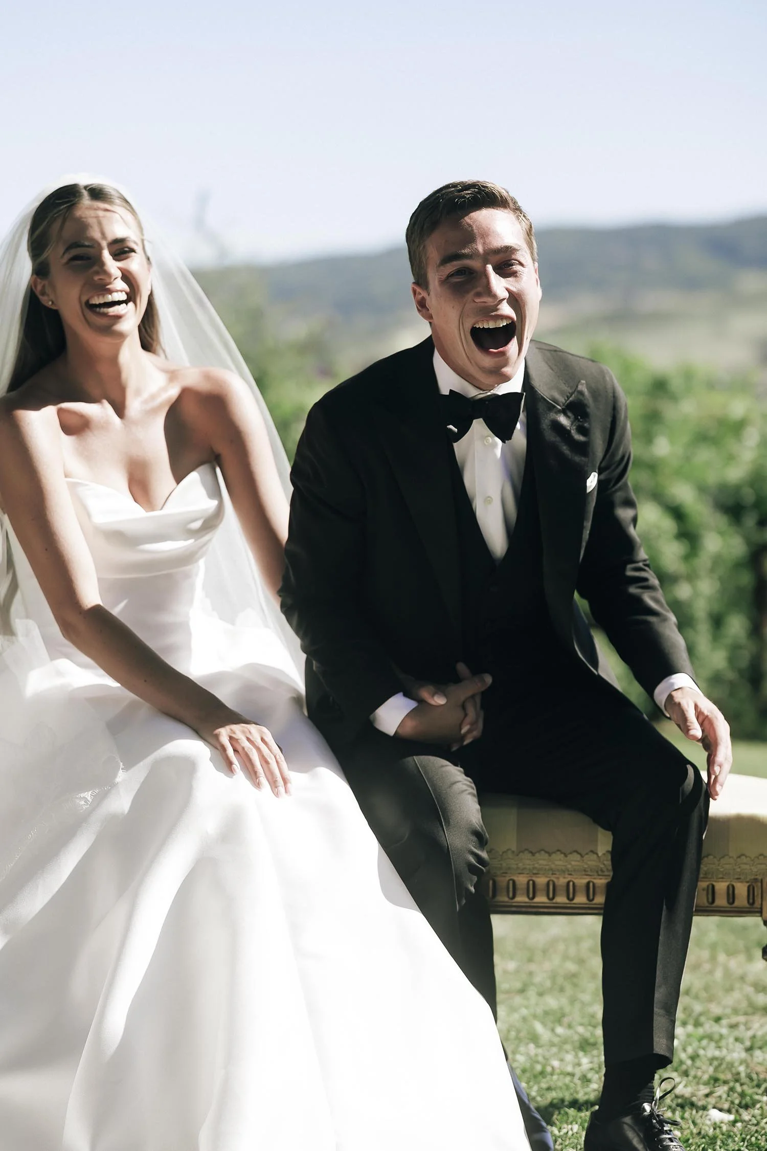 bride and groom sitting and laughing during the ceremony
