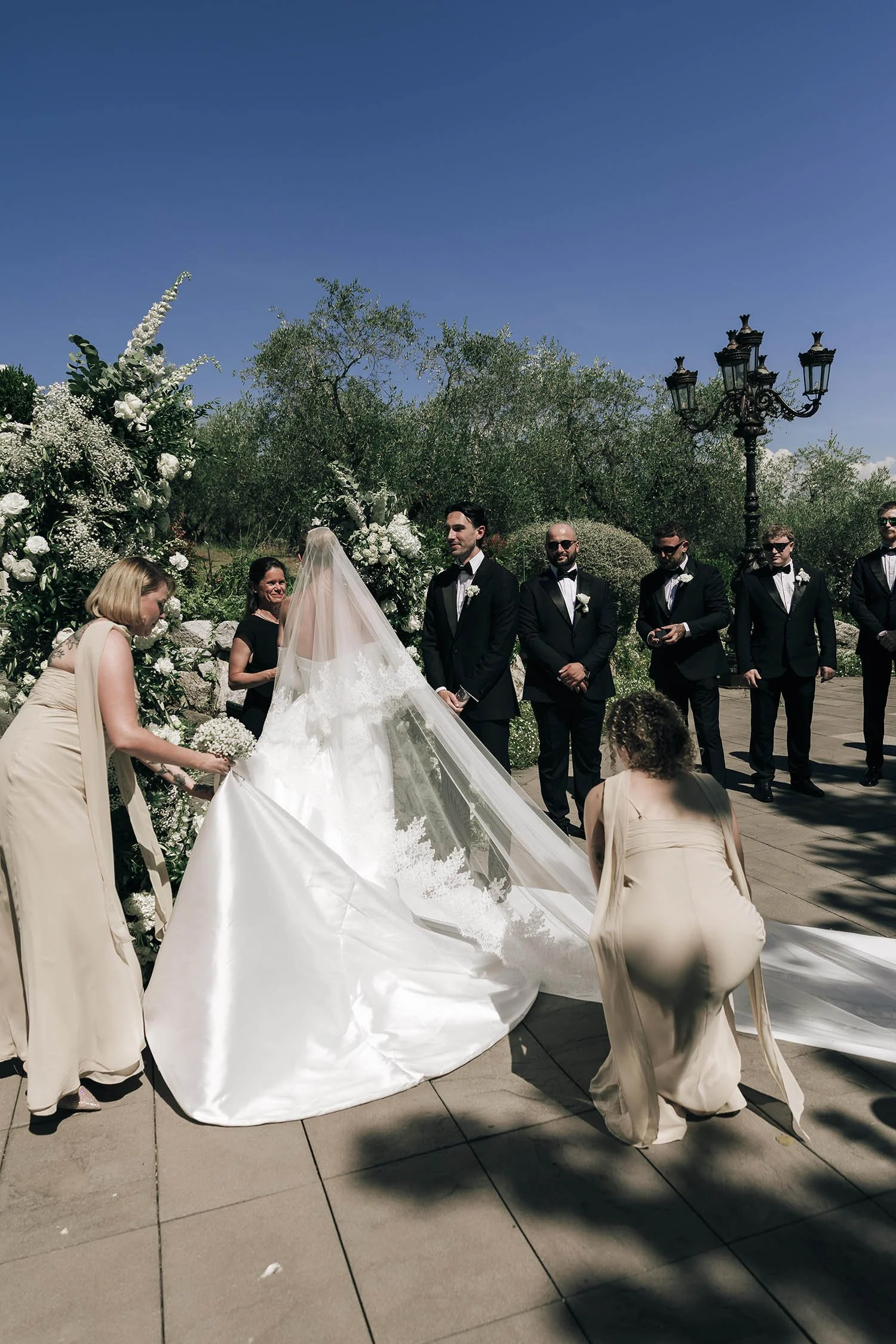 bride walking down the aisle with her father, wit the groom looking very emotional