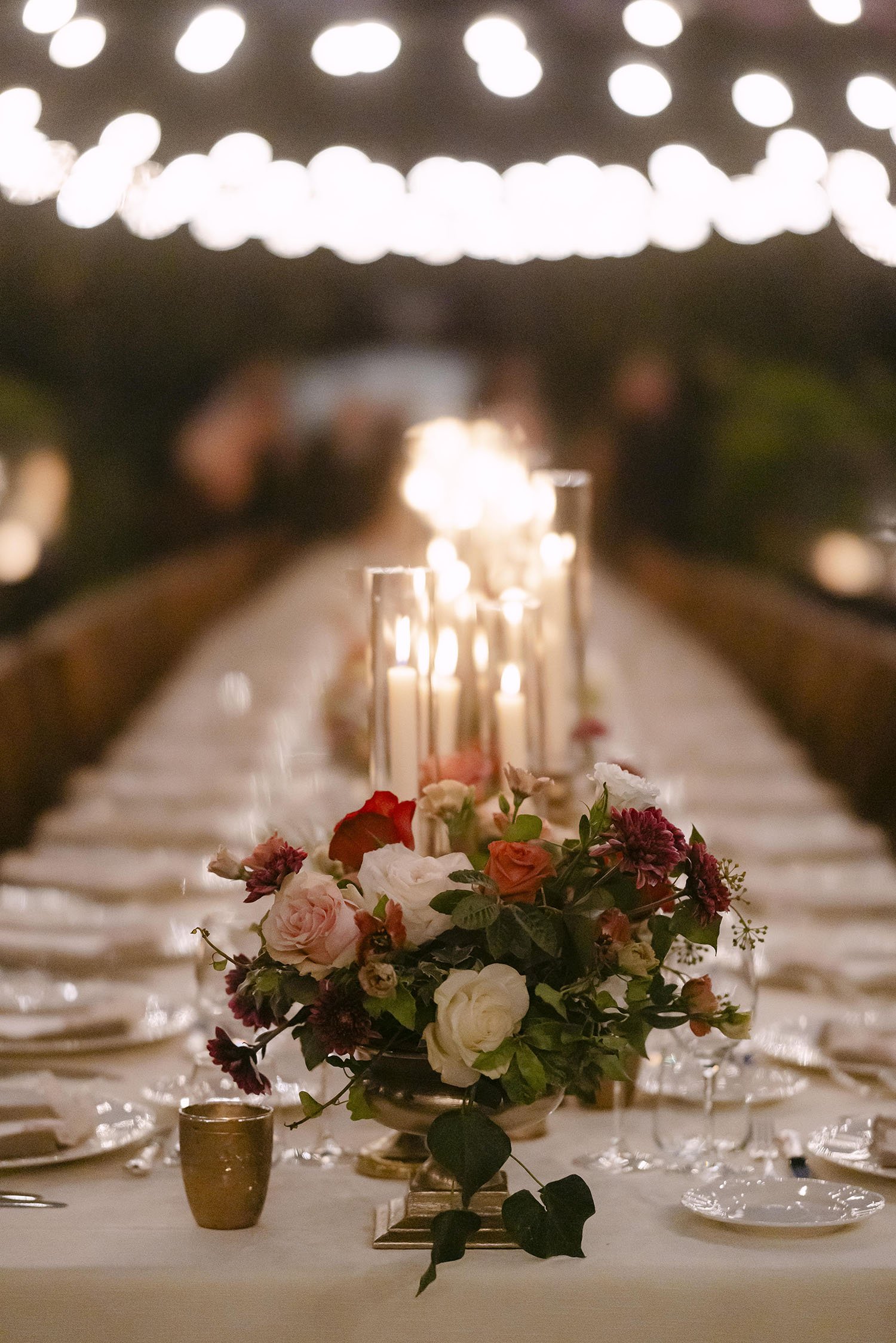 Details of the dinner decor with candles under the fairy lights