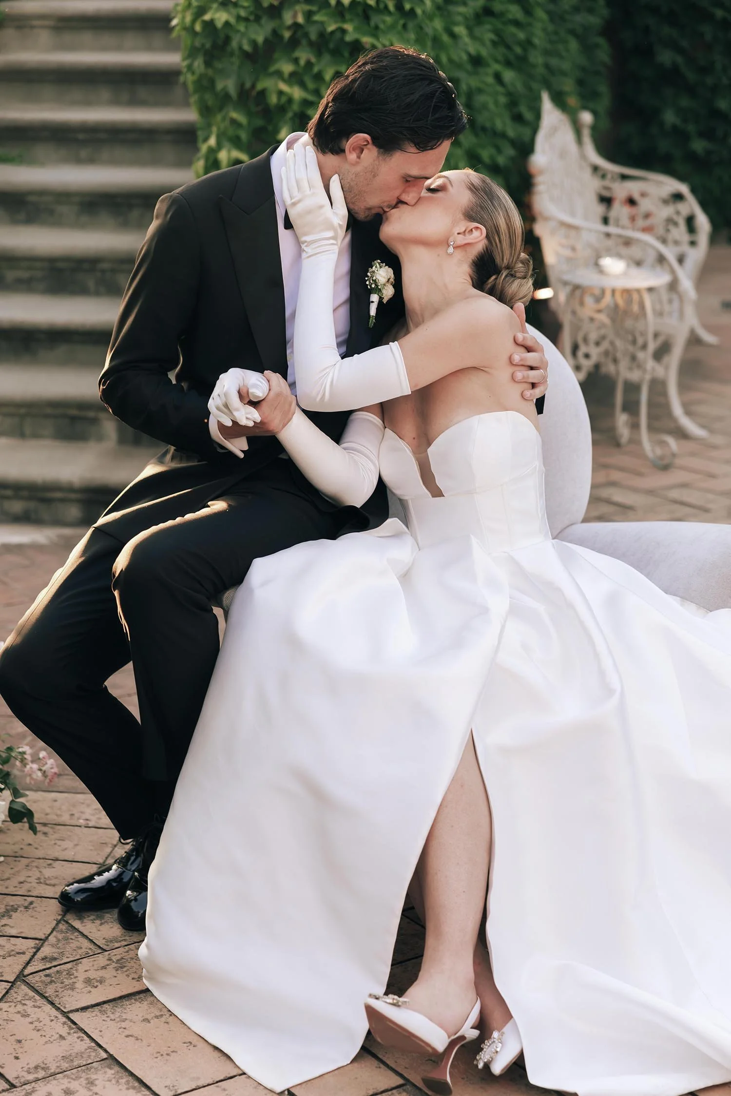 Bride and groom sitting on an armchair and kissing