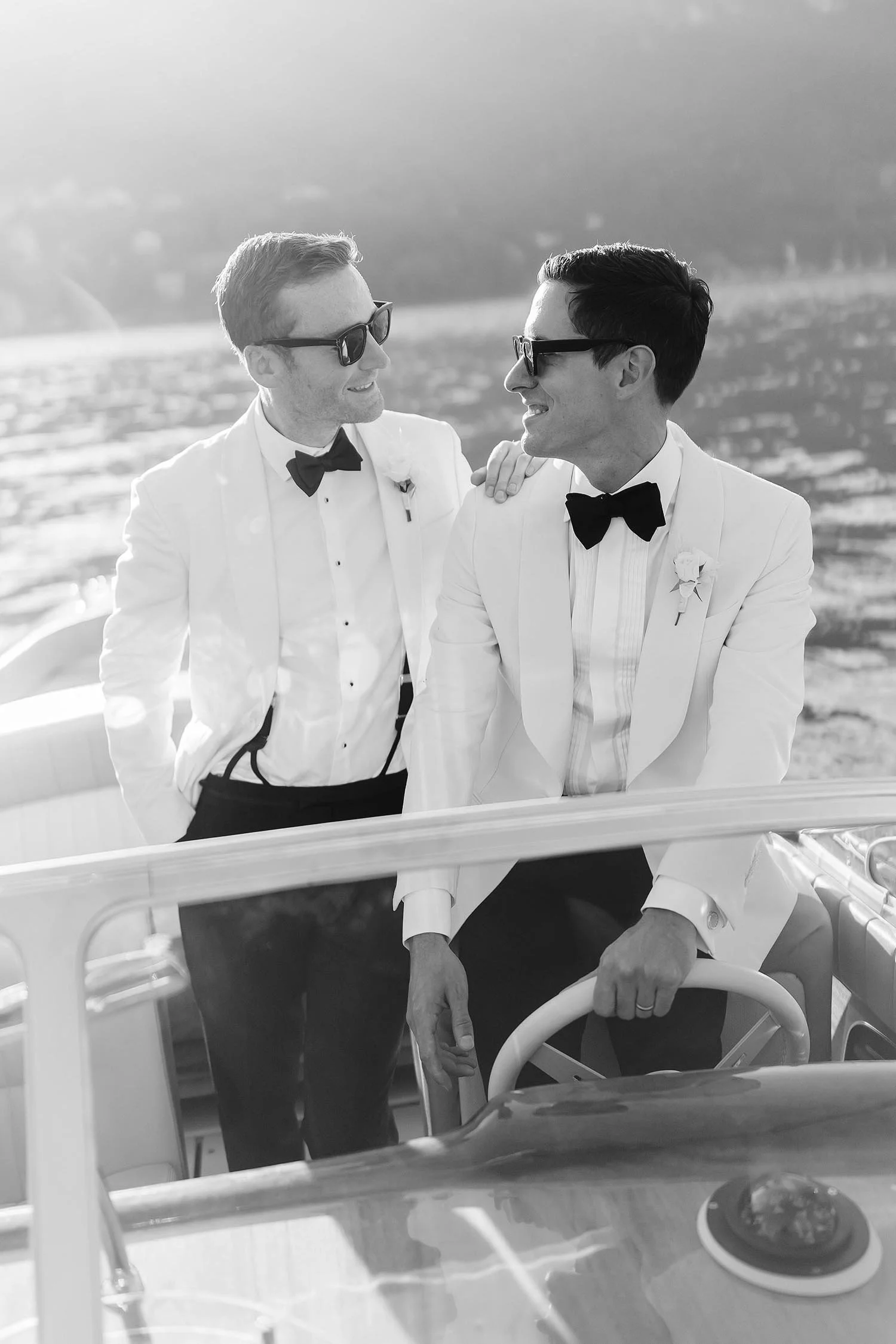 Same sex portrait of two grooms on a Riva boat in Lake Como at sunset looking classy and happy.  photo by Rellini art studio best wedding photographers in Italy