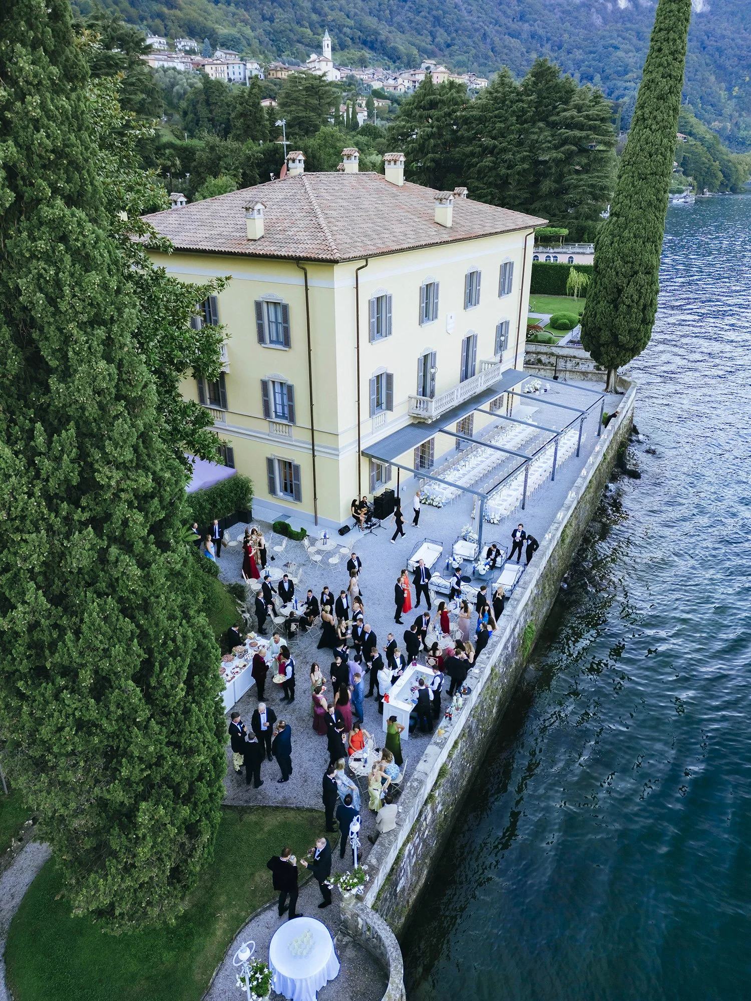 Aerial view of Villa Aura del Lago in Lake Como with guests enjoying aperitivo and Cocktail on a same sex destination wedding. Photo by Rellini art studio, same sex wedding photographers in Italy