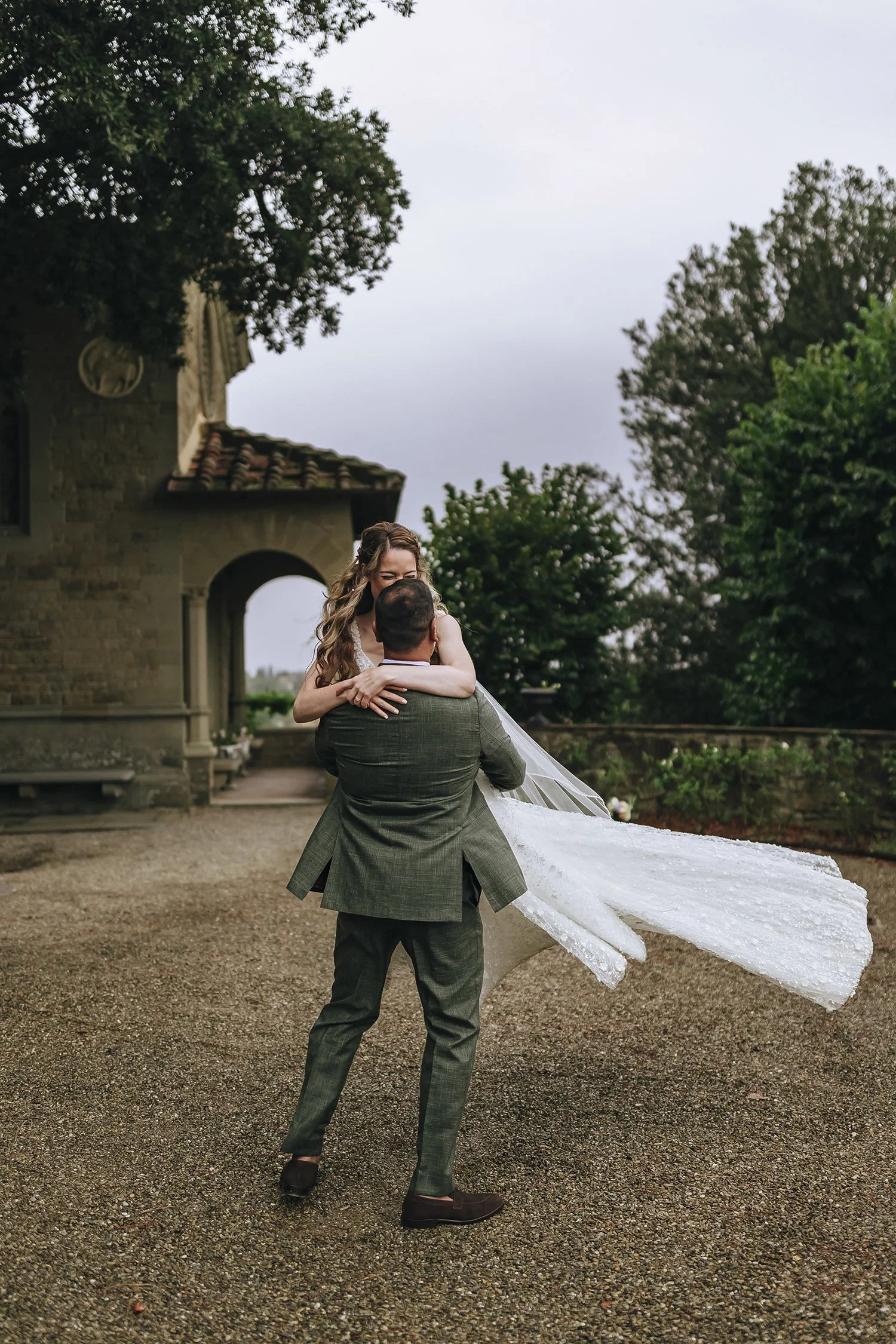 groom and bride dancing together in the rain at Villa le Fontanelle in Florence