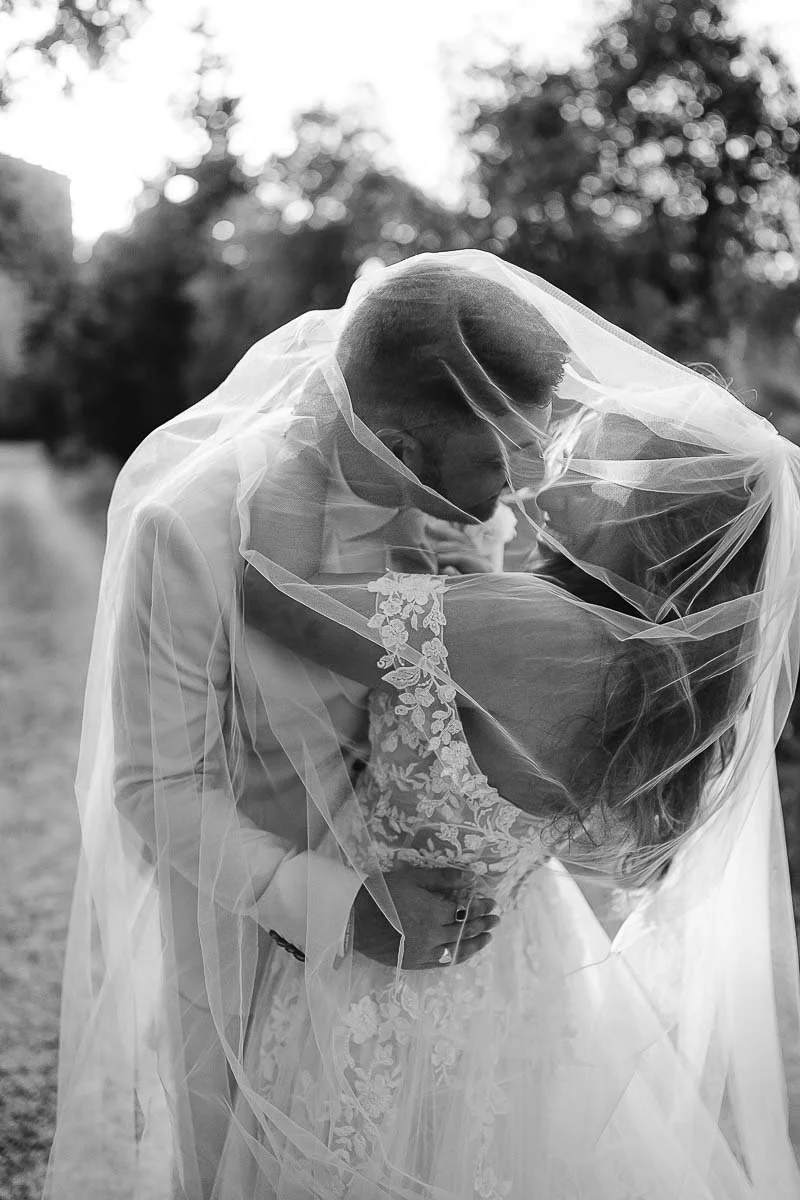 Destination wedding at Ristonchi castle near Florence in Tuscany. bride and groom kiss each other under the veil