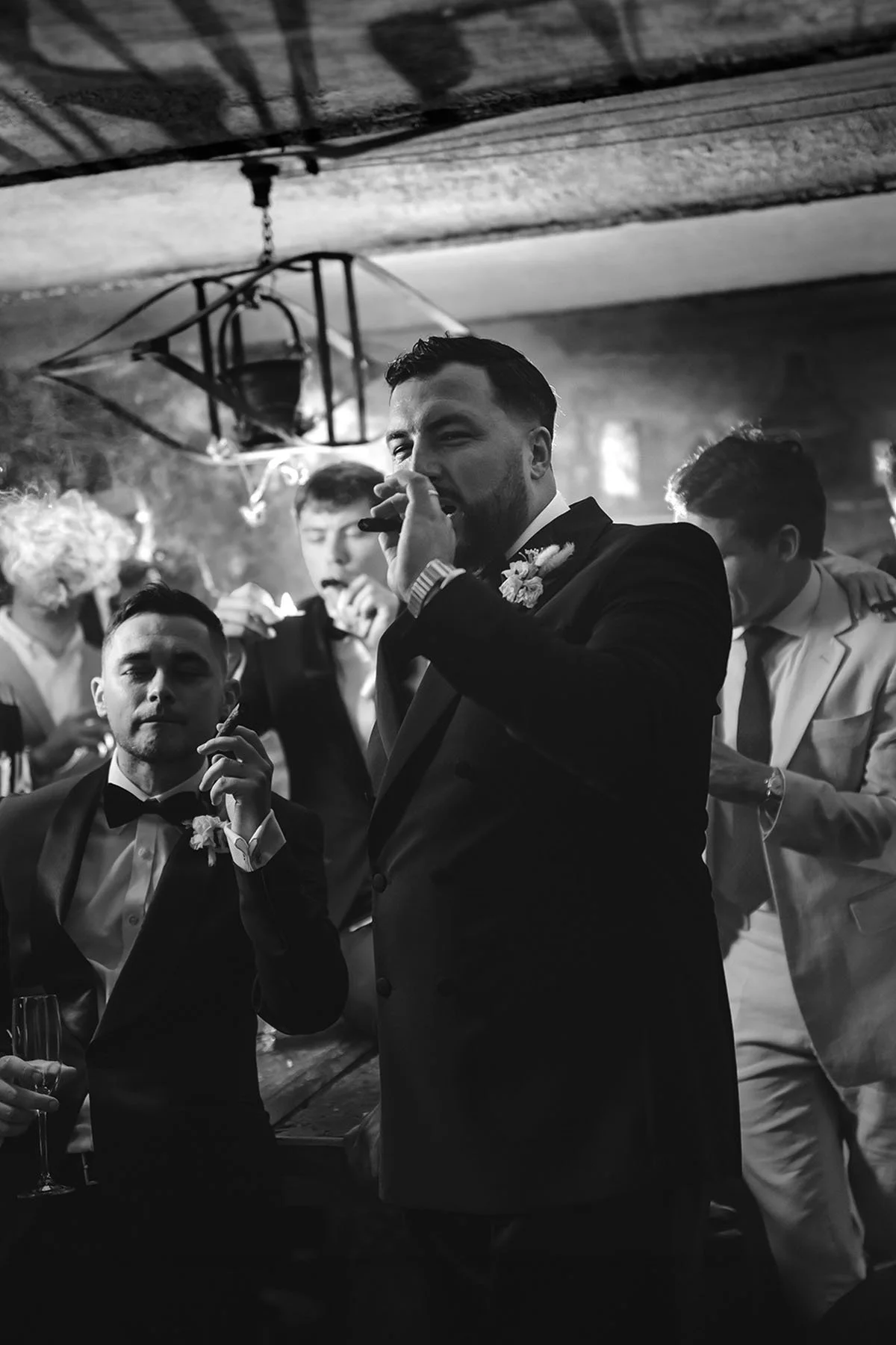 Destination wedding in Italy, photo by Rellini art studio best wedding photographers in Tuscany. Groom and groomsmen smoking cigars at Castello il Palagio