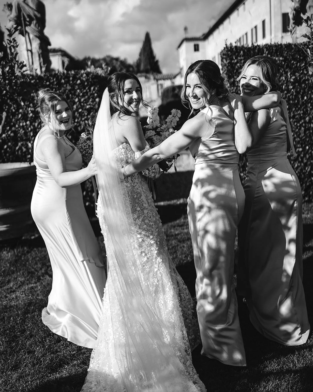 Bride walking with her bridesmaids and holding each other