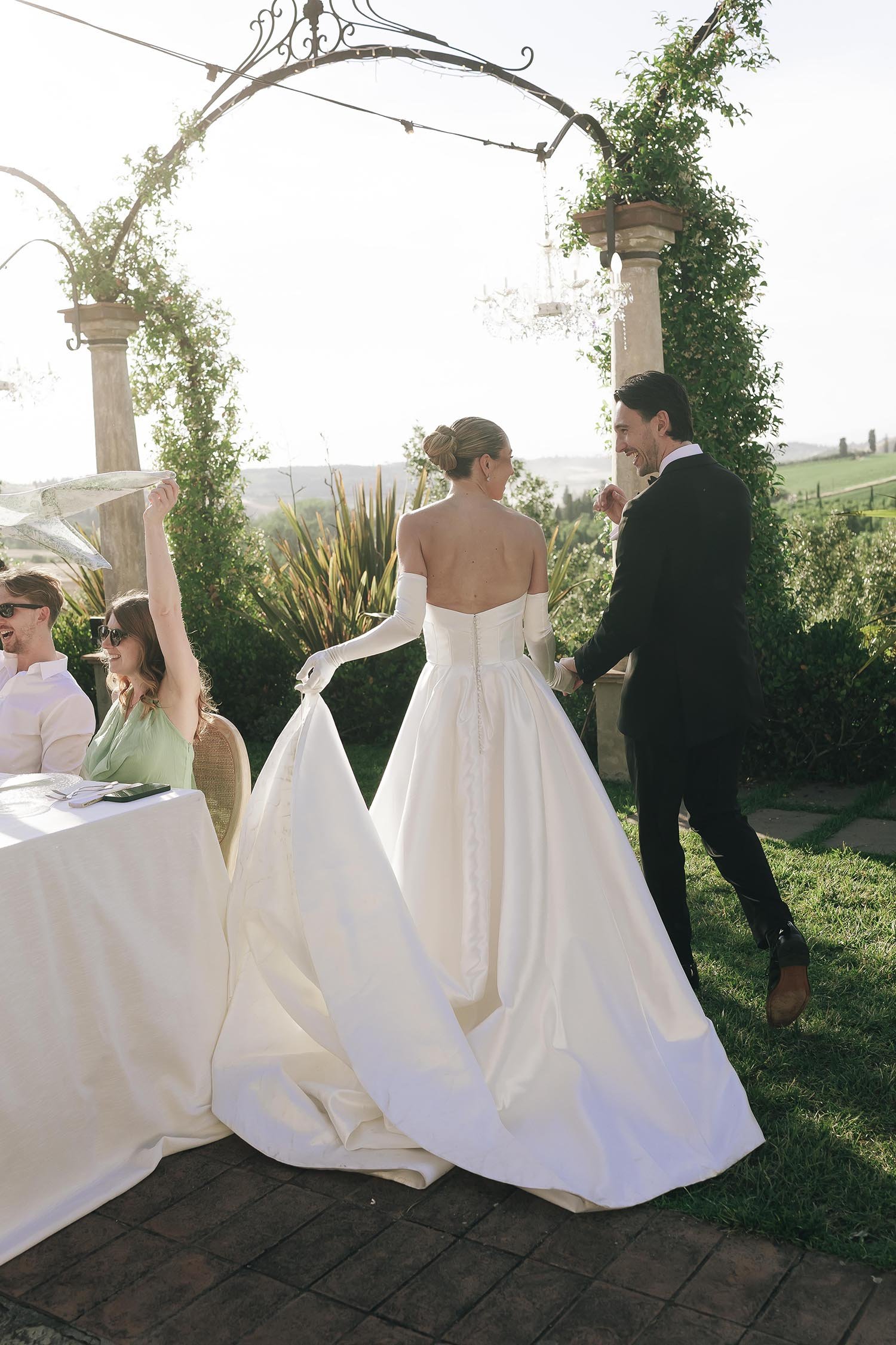 Bride and groom enter the dinner area and walk to the tables celebrated by their guests