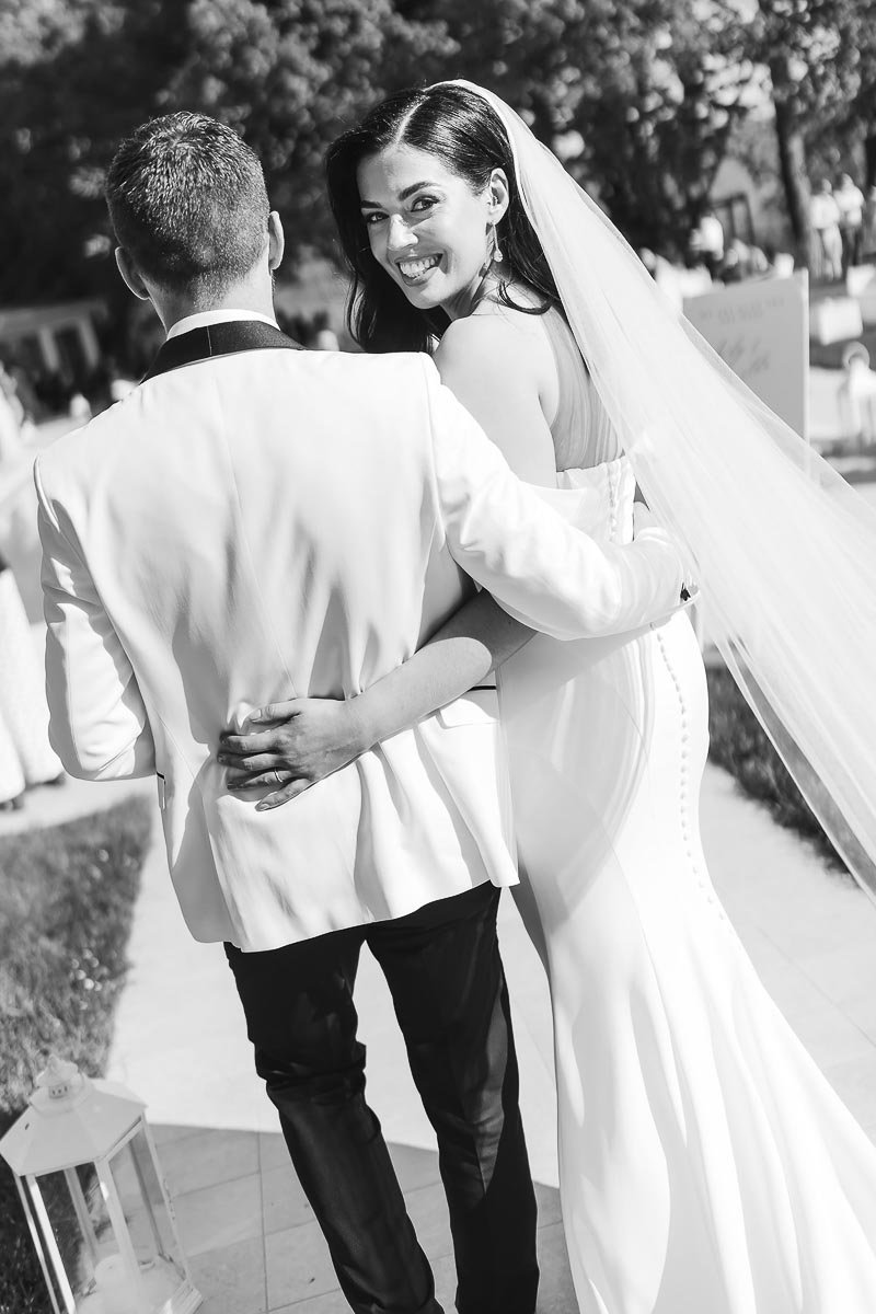 candid photo of the bride and groom walking by the pool at Castello di Montignano