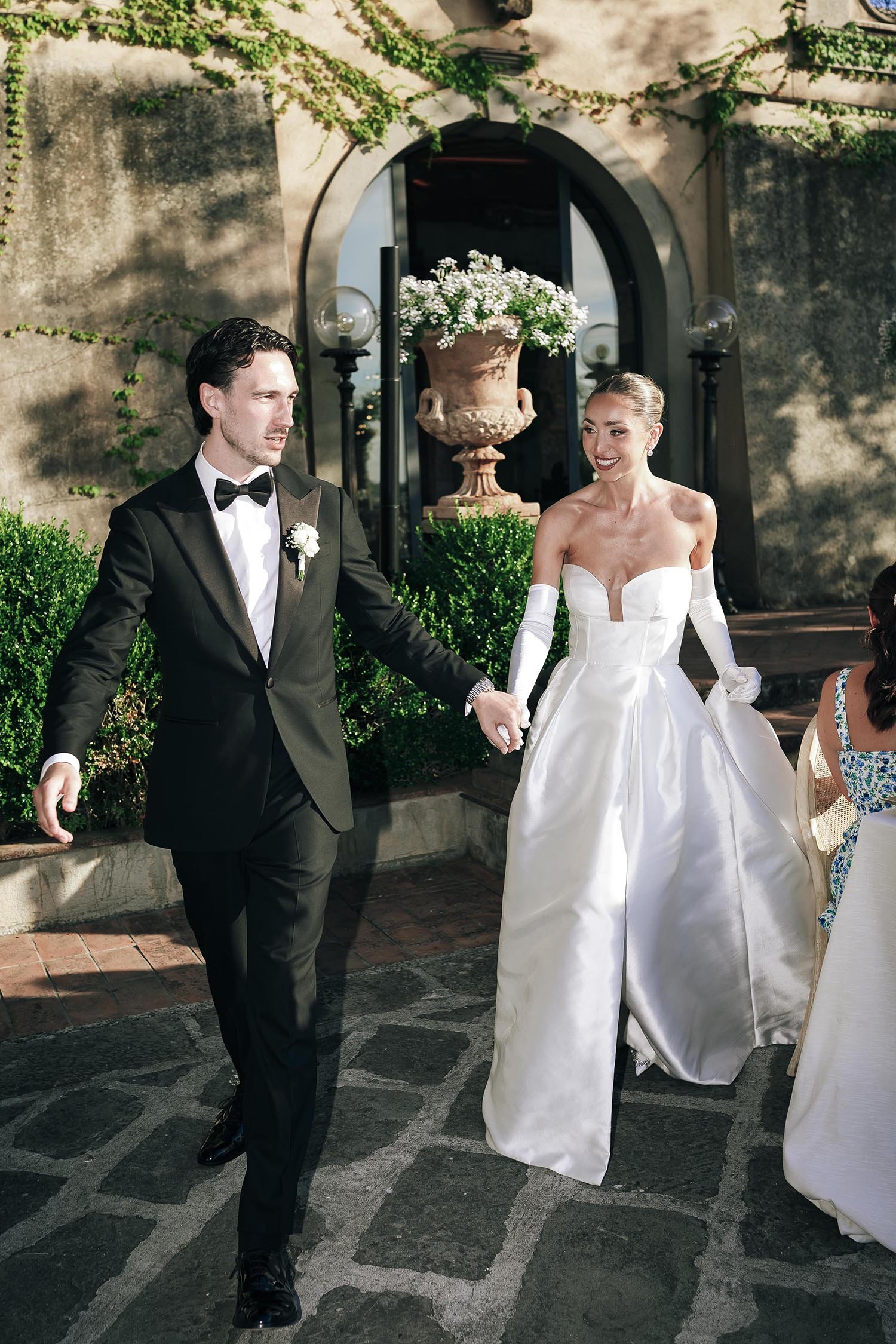 Bride and groom enter the dinner area and walk to the tables celebrated by their guests