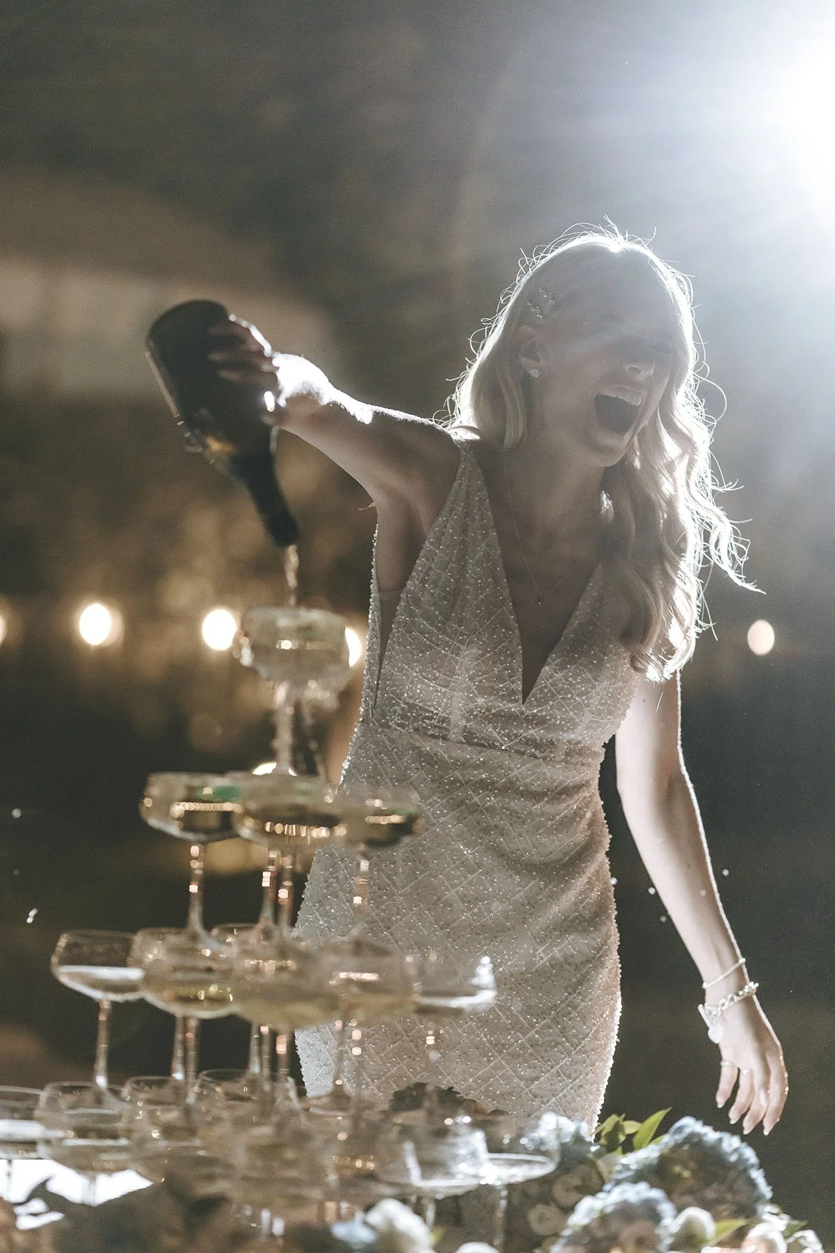 editorial style photo pf the bride filling her champagne tower on their destination wedding in Tuscany with magazine style by Rellini art studio, best wedding photographers in Italy