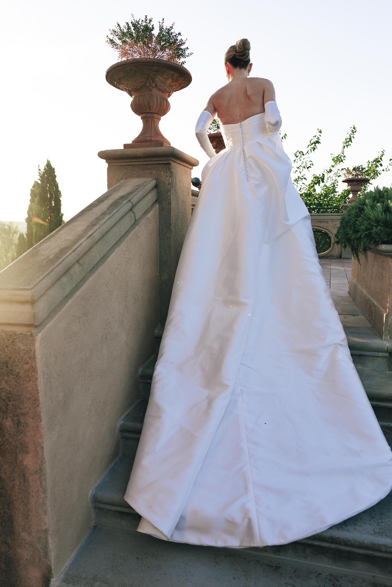 the bride walking the stairs and showing the full dress at Tenuta Corbinaia