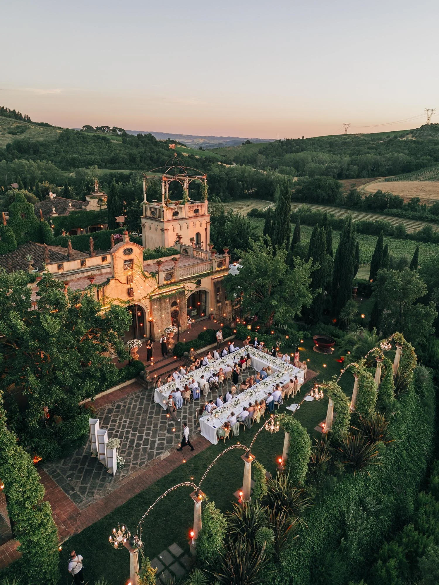 aerial view of te guests seated for dinner with the sun setting on Tenuta Corbinaia