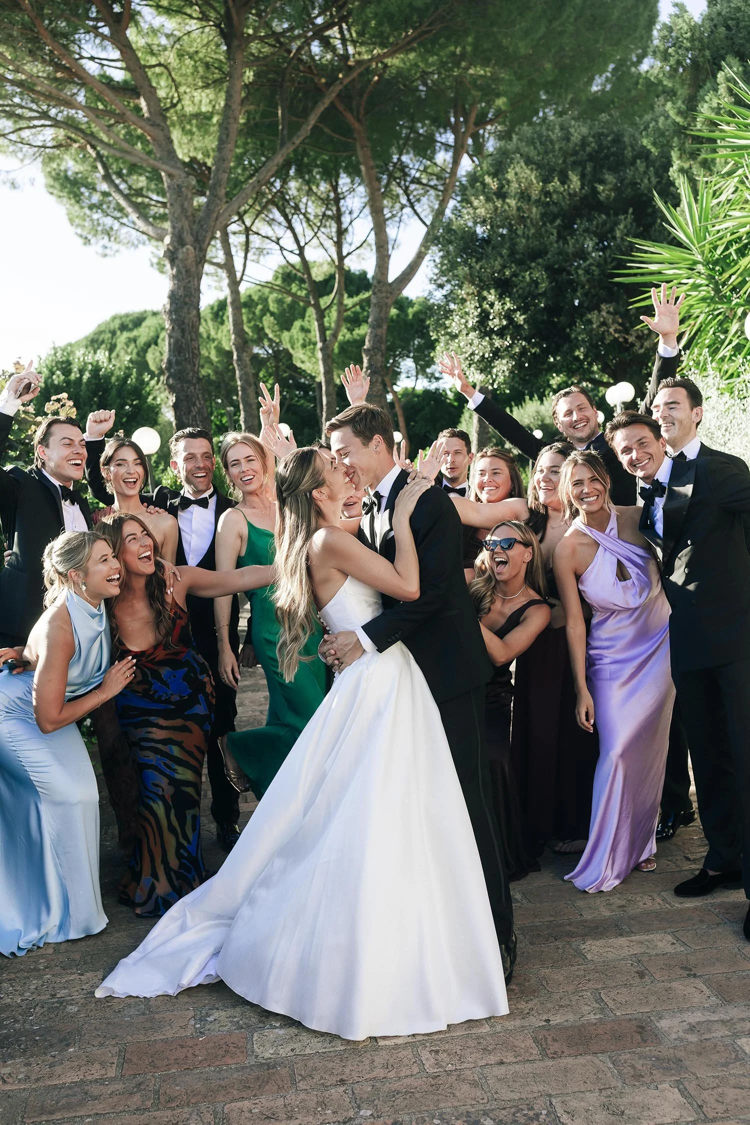 bride and groom kiss each other in front of their friends