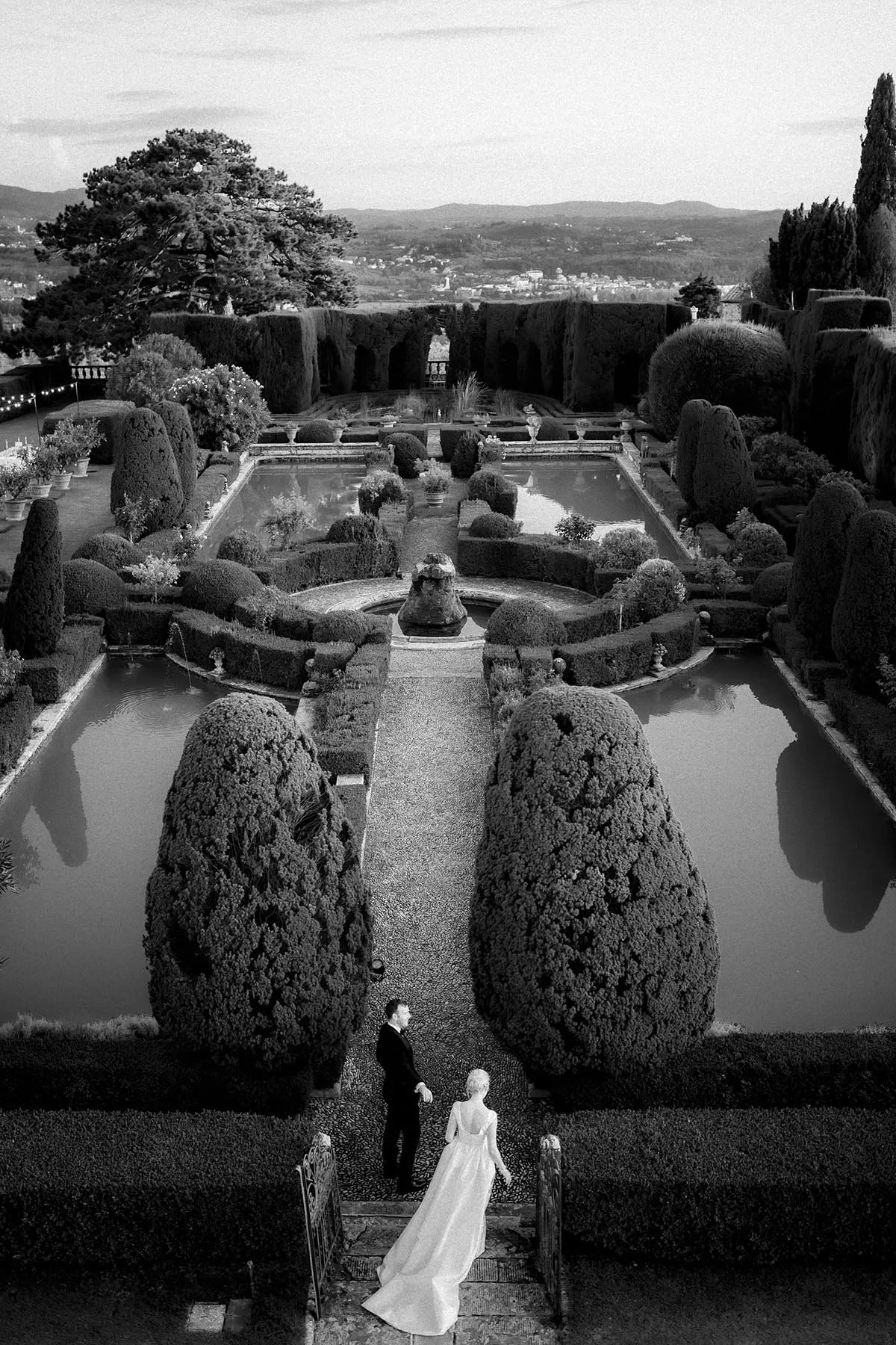 aerial view of bride and groom walking in the gardens at sunset at Villa Gamberaia in Florence