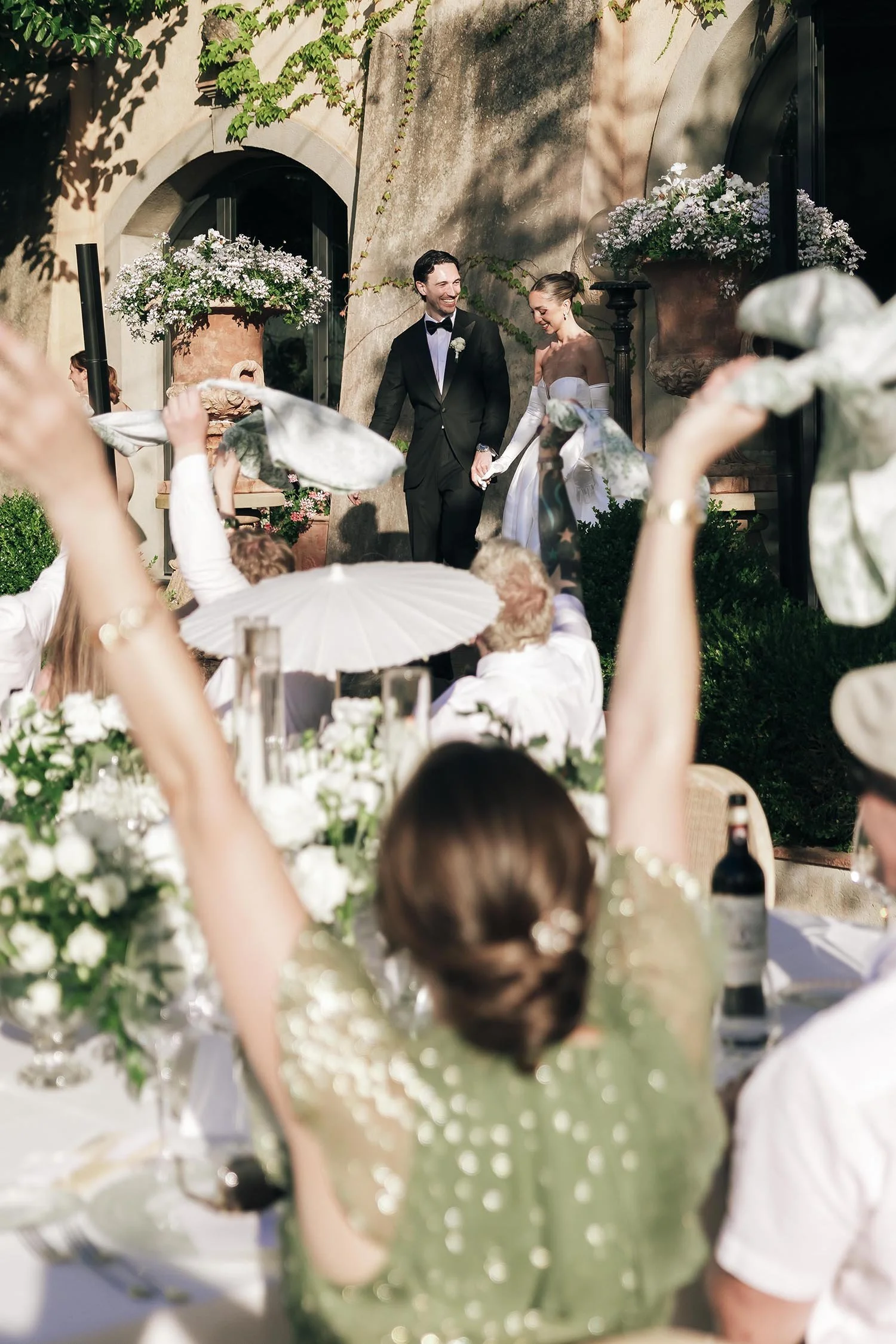 Bride and groom enter the dinner area and walk to the tables celebrated by their guests