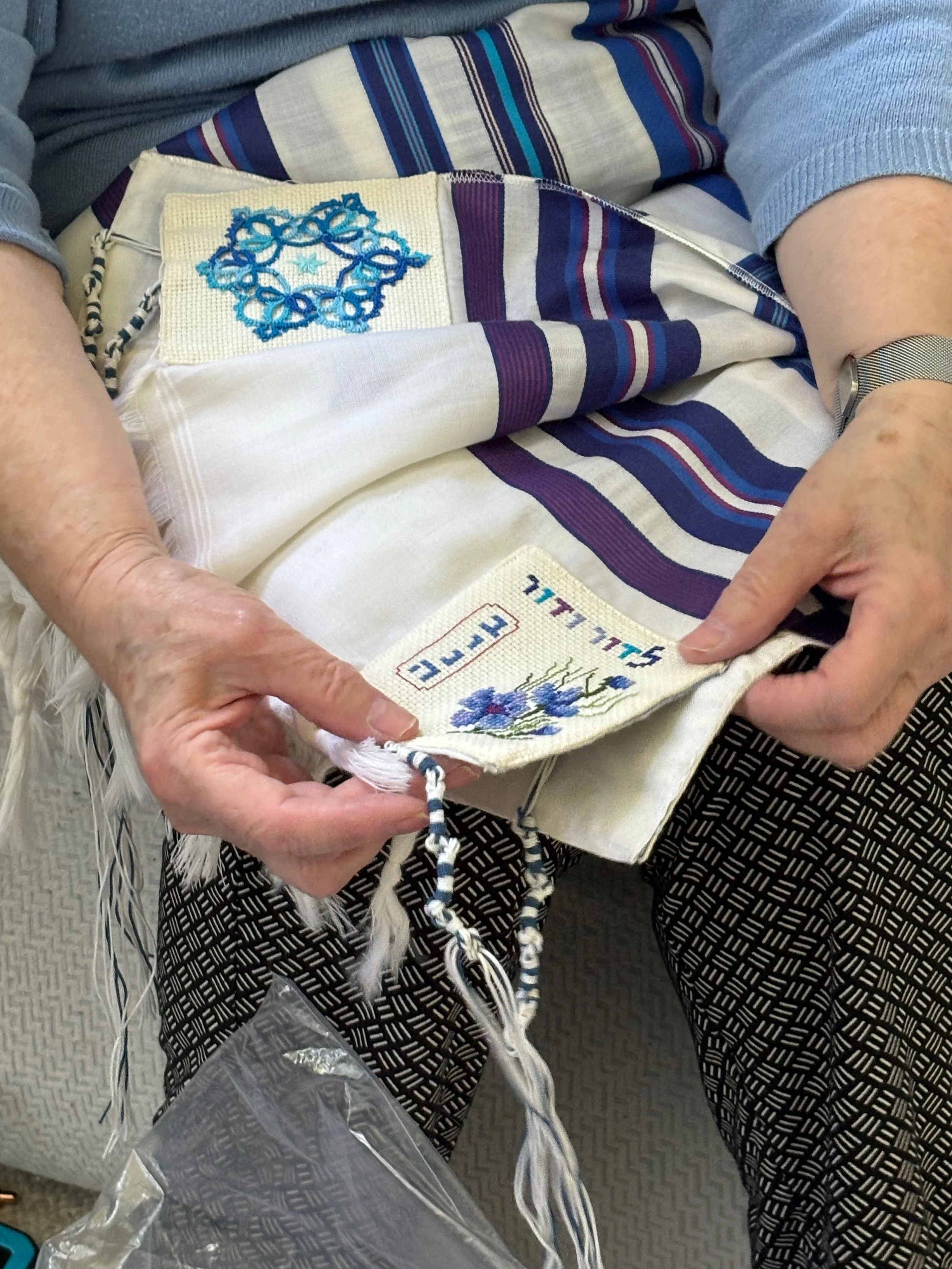 I helped this woman who's like 98 years old and she's like this amazing artisan and this is a Talit, which is, it's a Jewish prayer shawl, but she's showing me the embroidery that she did for her grandson and I just think it's pretty cool and she did