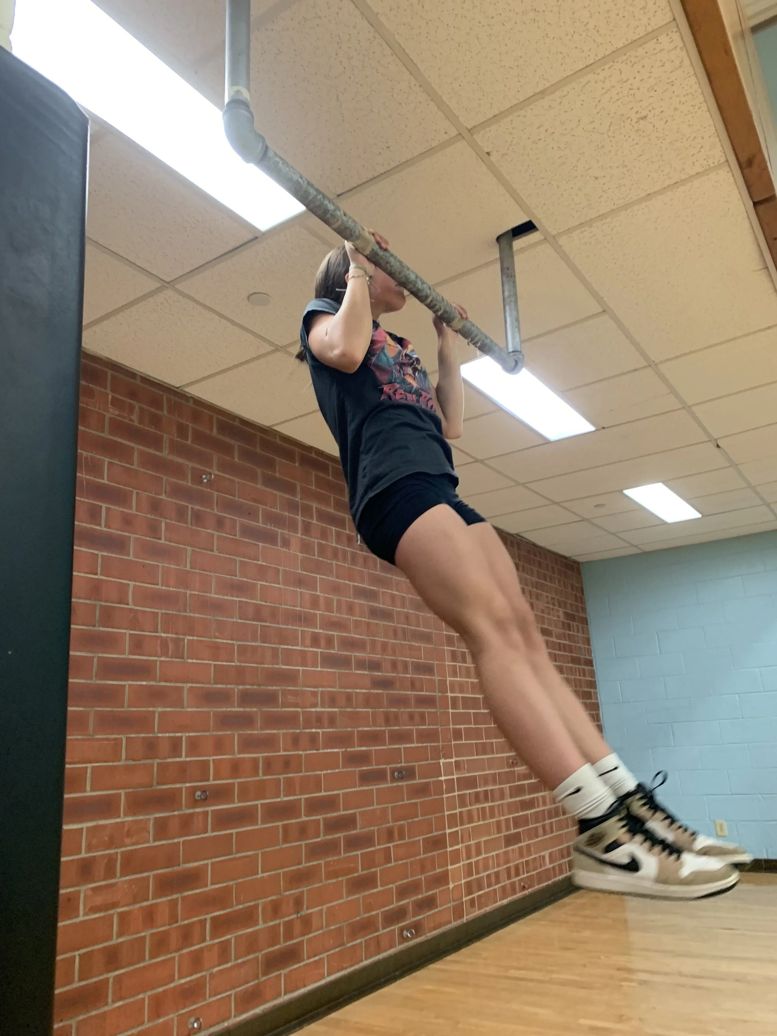 Anyone can see the raw power of this young woman as she is about to raise her chin over the pull up bar. Only people who have met her
would know what a compassionate friend and teammate she is. Her encouragement and smiles lift up our swim team, as w
