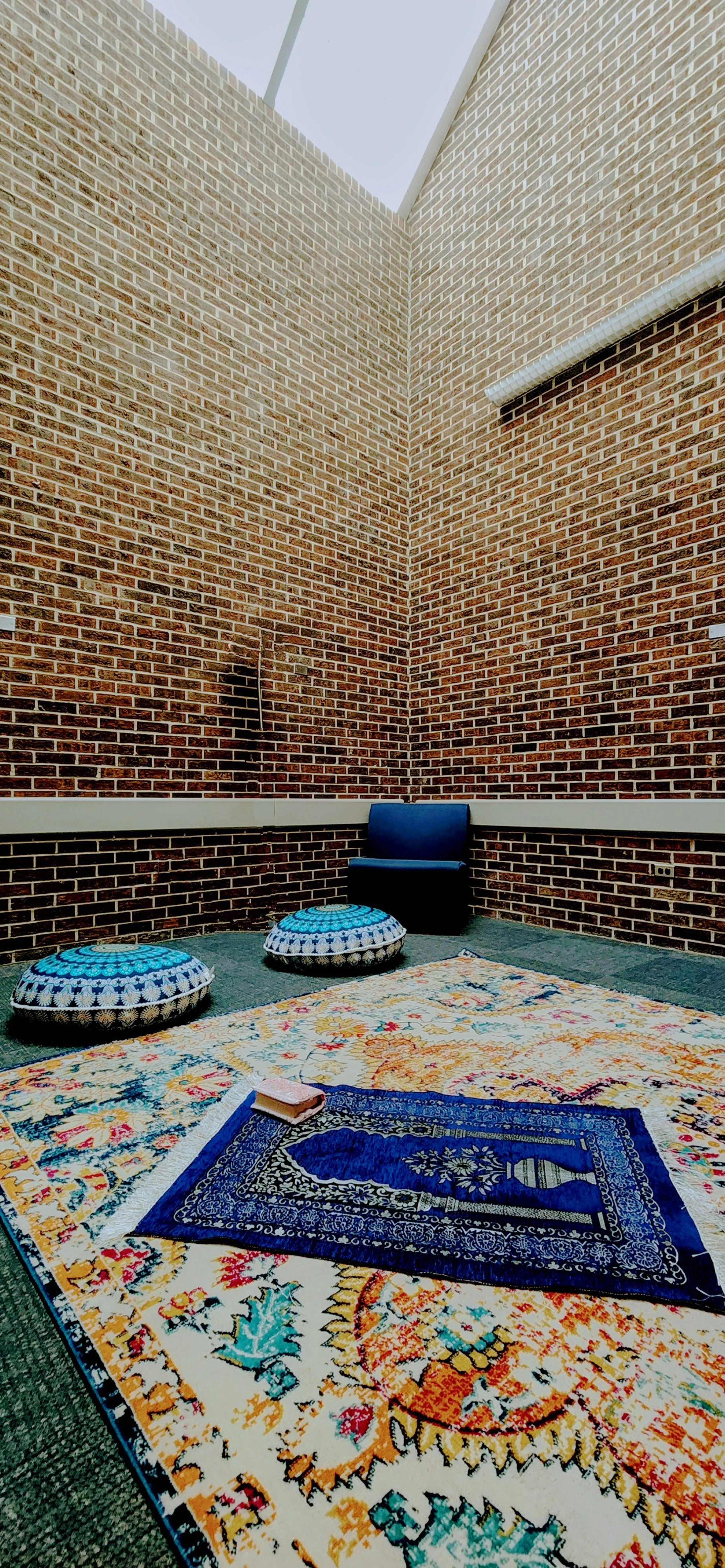 "This photograph captures a moment of tranquility within one of the Interfaith Reflection Rooms at GVSU, where individuals from diverse backgrounds come together to pray. In Islam, prayer, being the second pillar of the faith, holds significant impor