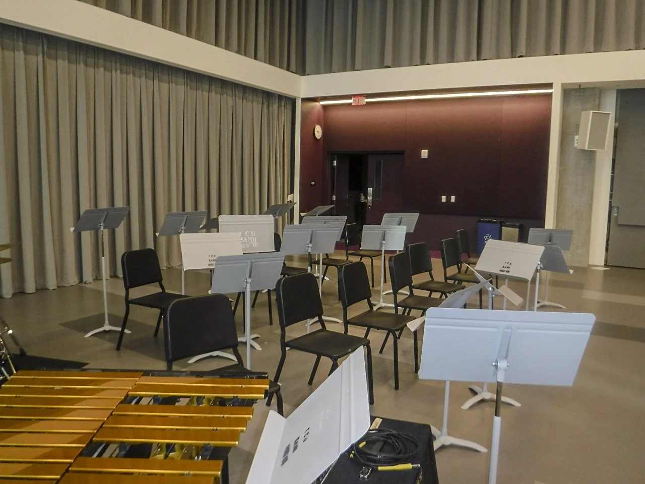 "These are some scattered music stands in the music building at TCU. A music stand holds a musician's music when playing or using their instrument. Although all music stands function similarly, they all carry different types of music for various inst