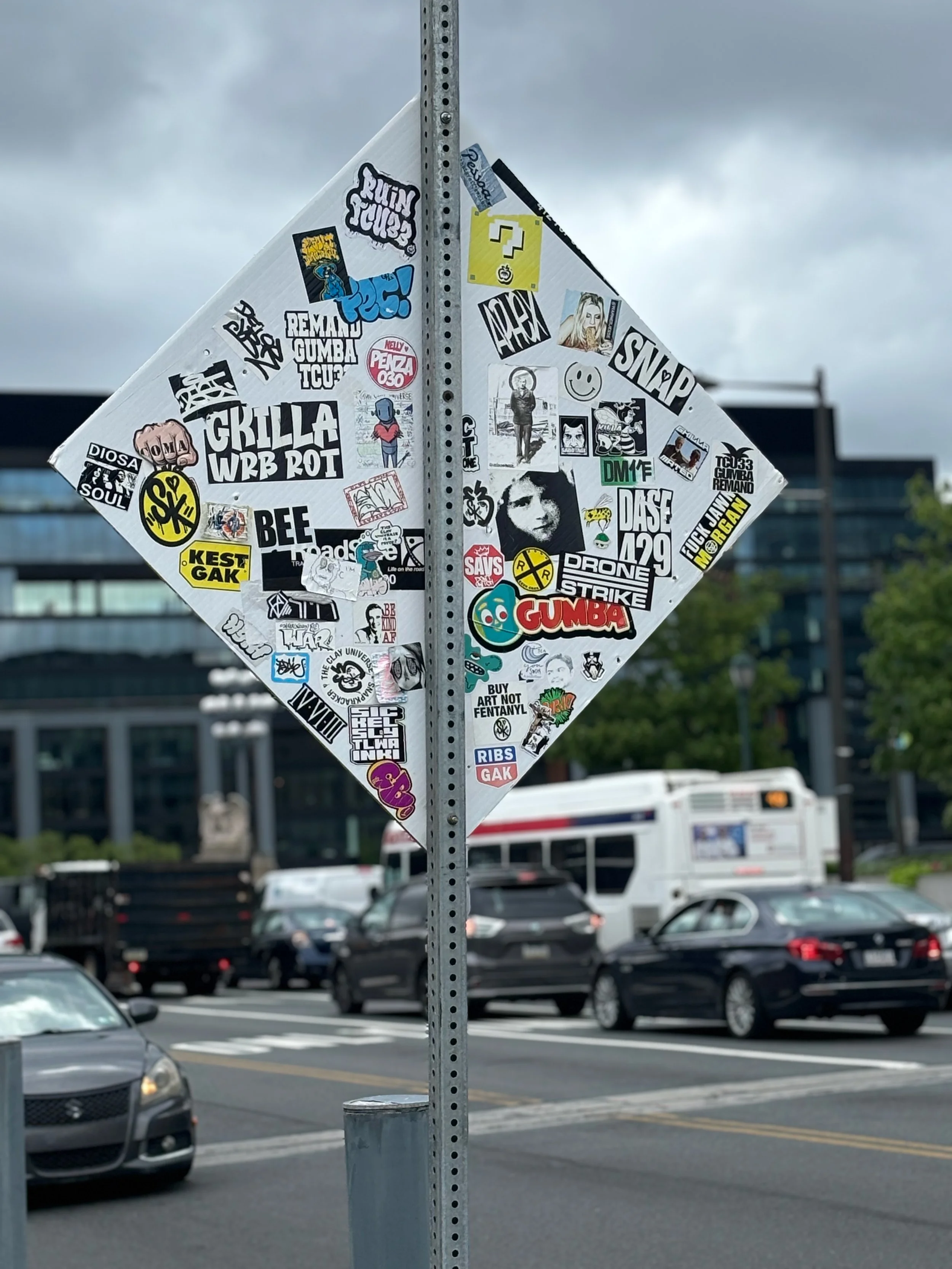 This image in the center of the street sign looks like Anne Frank, a young Jewish-German girl who died at the Bergen-Belsen concentration camp in 1945. However, it is a just an image from a German postcard and some unrelated propaganda. It would be i