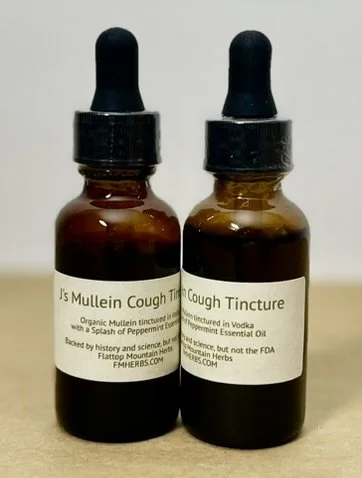 Two small amber glass bottles labeled 'Js Mullein Cough Tincture' and 'Cough Tincture' with dropper caps.
