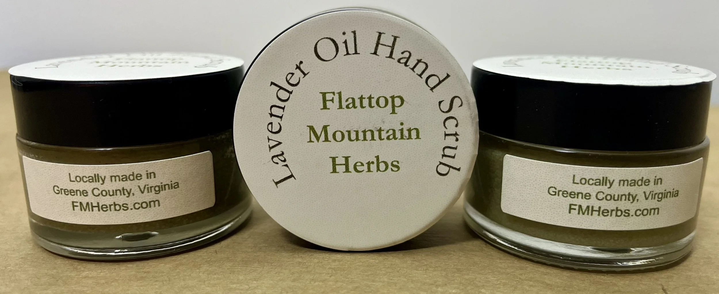 Two small jars of herbal product with labels indicating they are made in Greene County, Virginia, and a circular product label that reads "Lavender, Oil Hand Scrub", and "Flattop Mountain Herbs".