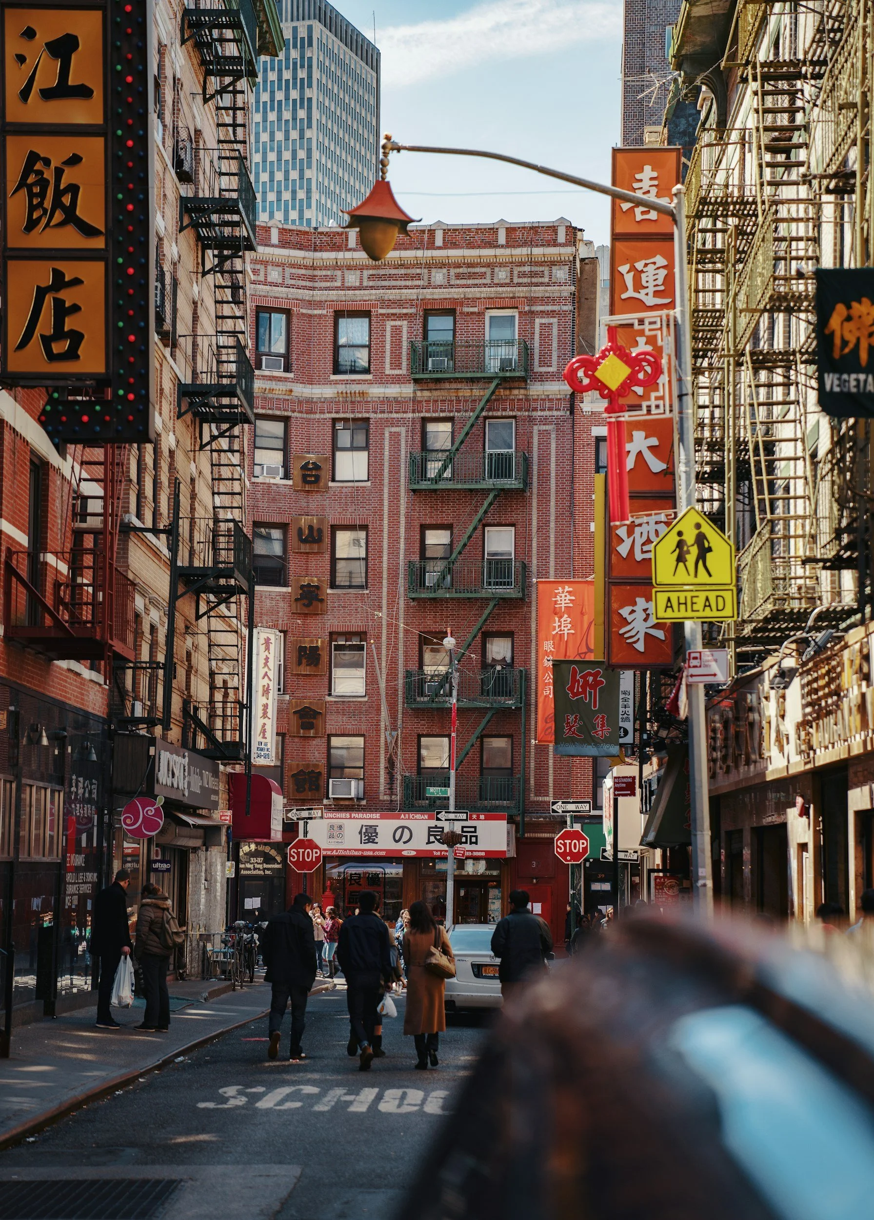 Image of a street in NYC's Chinatown with pedestrians walking in the street, neighborhood near NYC City Clerk's Office, the Marriage Bureau