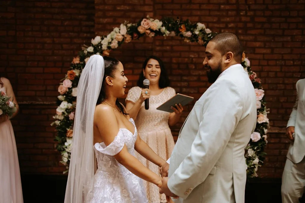A couple smiling during the wedding ceremony officiated by Brooklyn bilingual wedding officiant from Once Upon A Vow