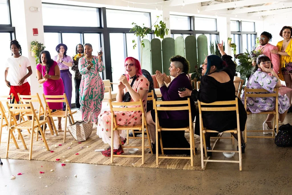 Wedding guests cheering on couple walking down the aisle during intimate wedding ceremony officiated by Brooklyn queer officiant from Once Upon A Vow at Brooklyn Grange