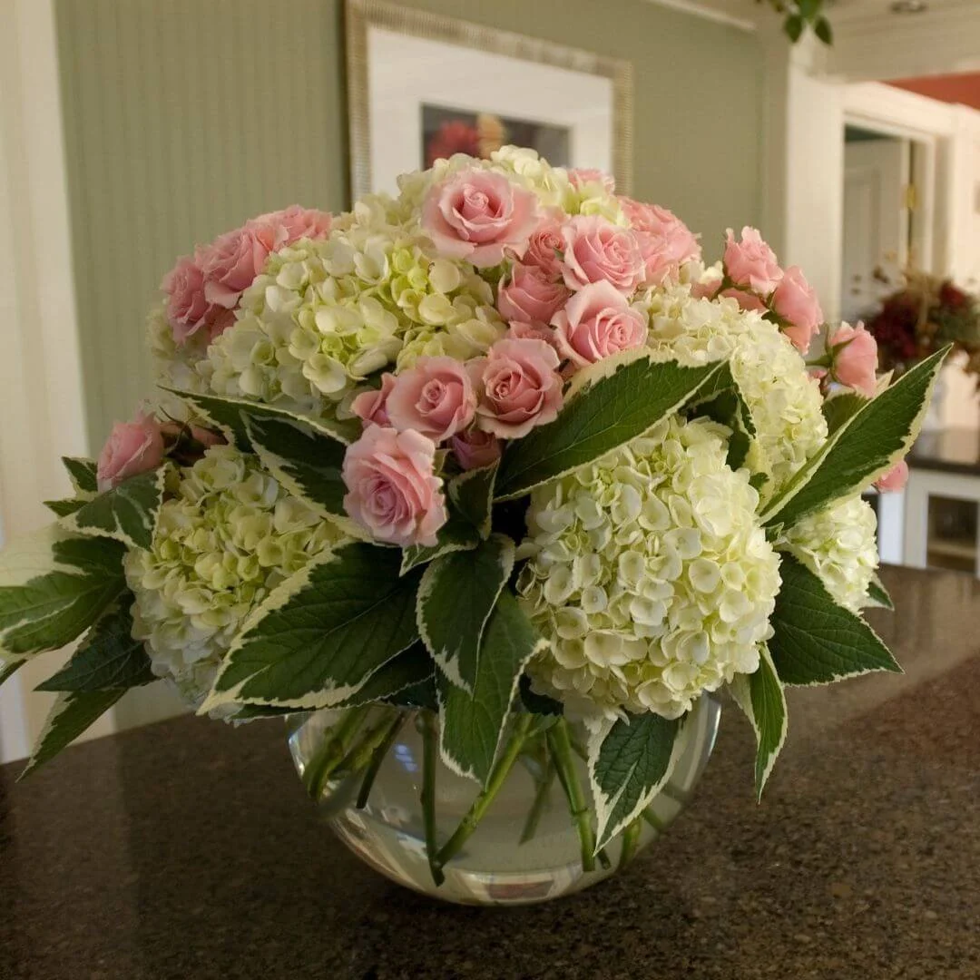 bouquet of cut flowers with blushing bride hydrangea and pink roses on countertop in house
