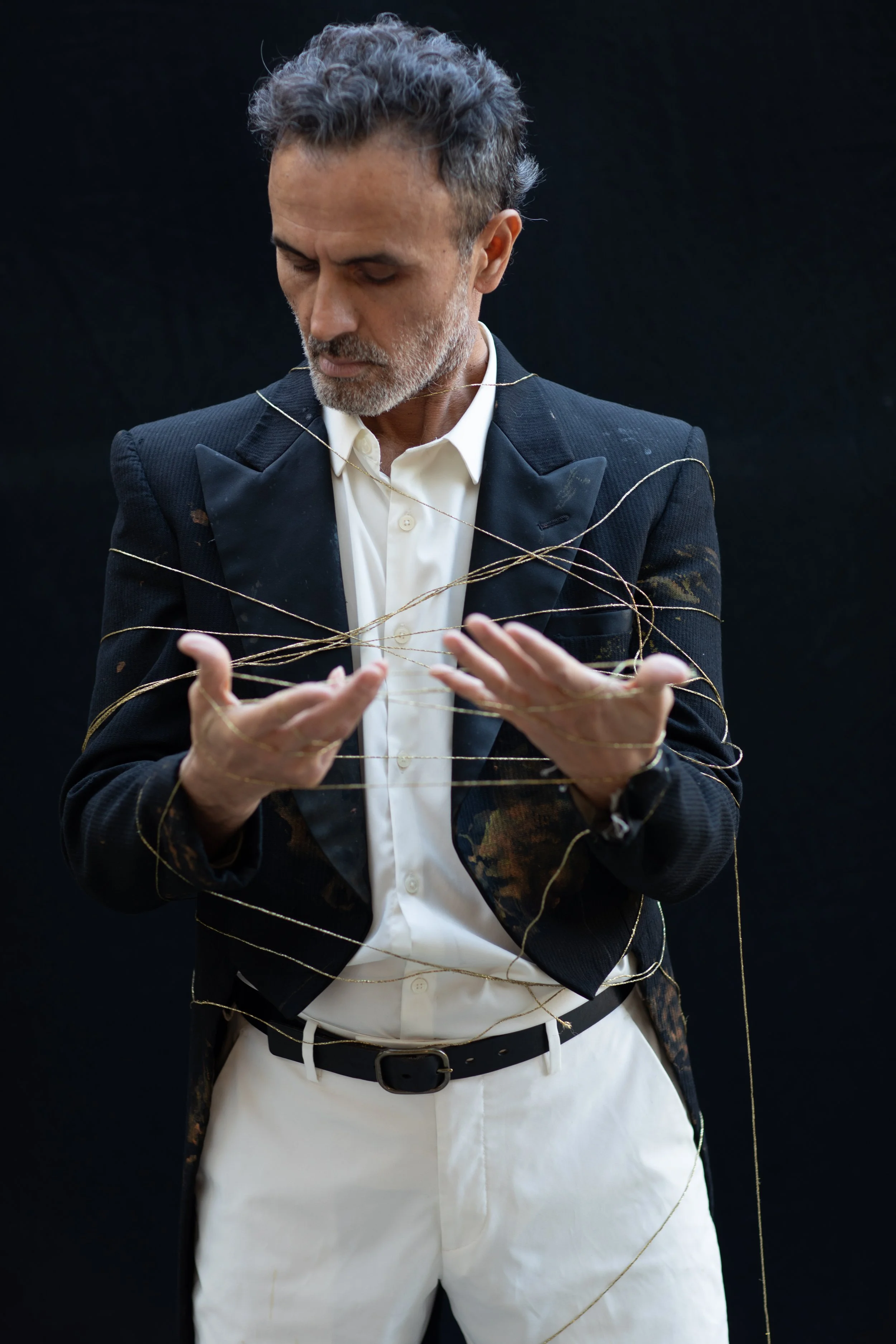 Man is now completely entangled in golden threads around his body.