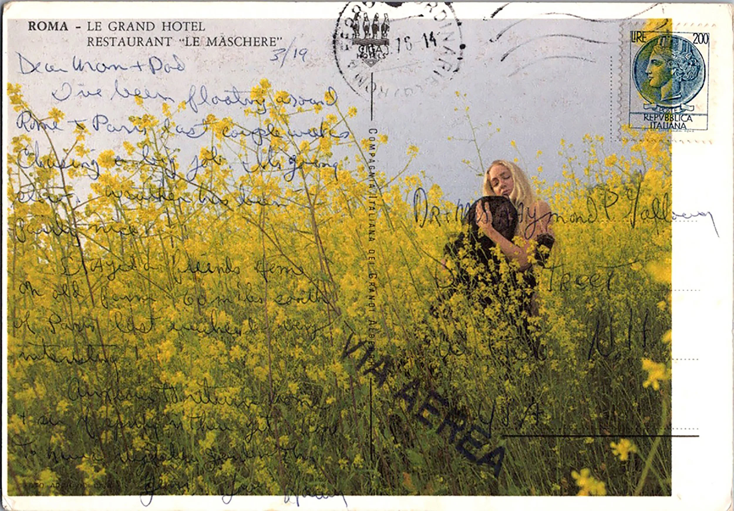 A nude woman and figure in black embrace in a field of yellow flowers