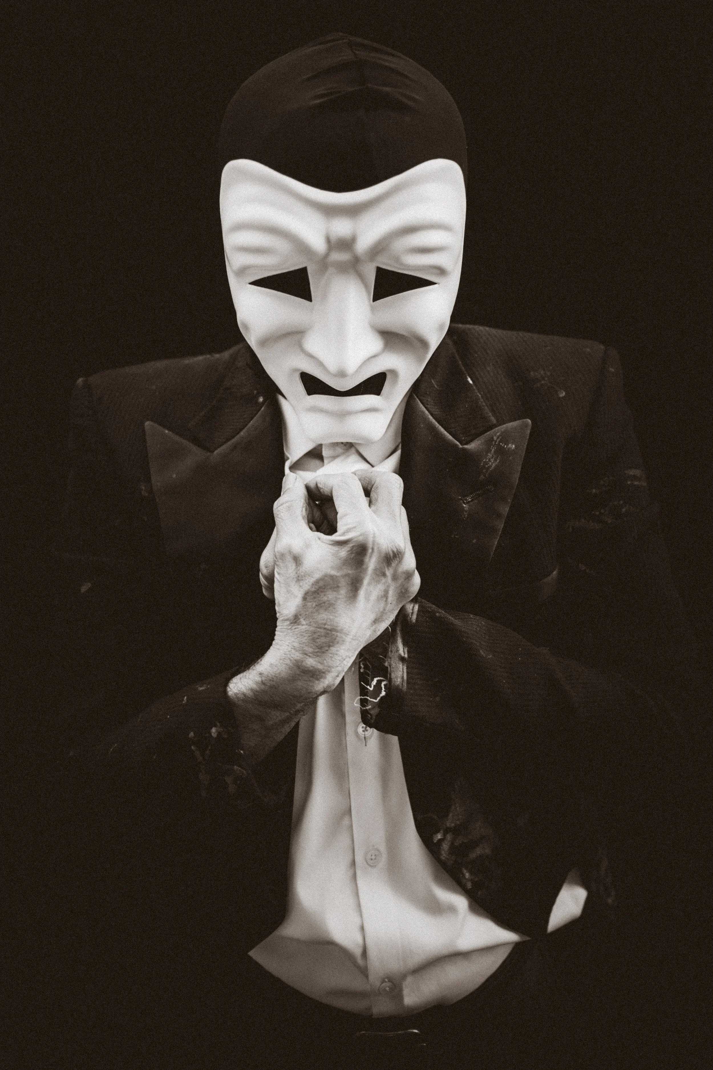 Man in a tux, wearing a drama mask.