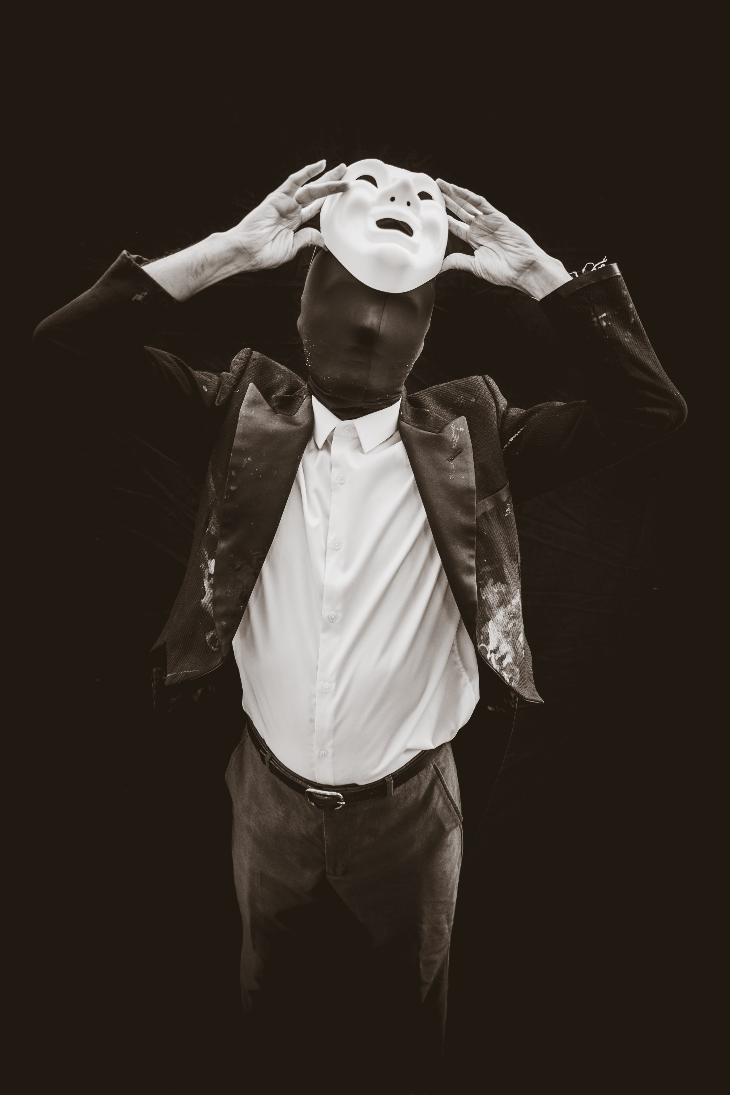 Masked man begins to remove mask.