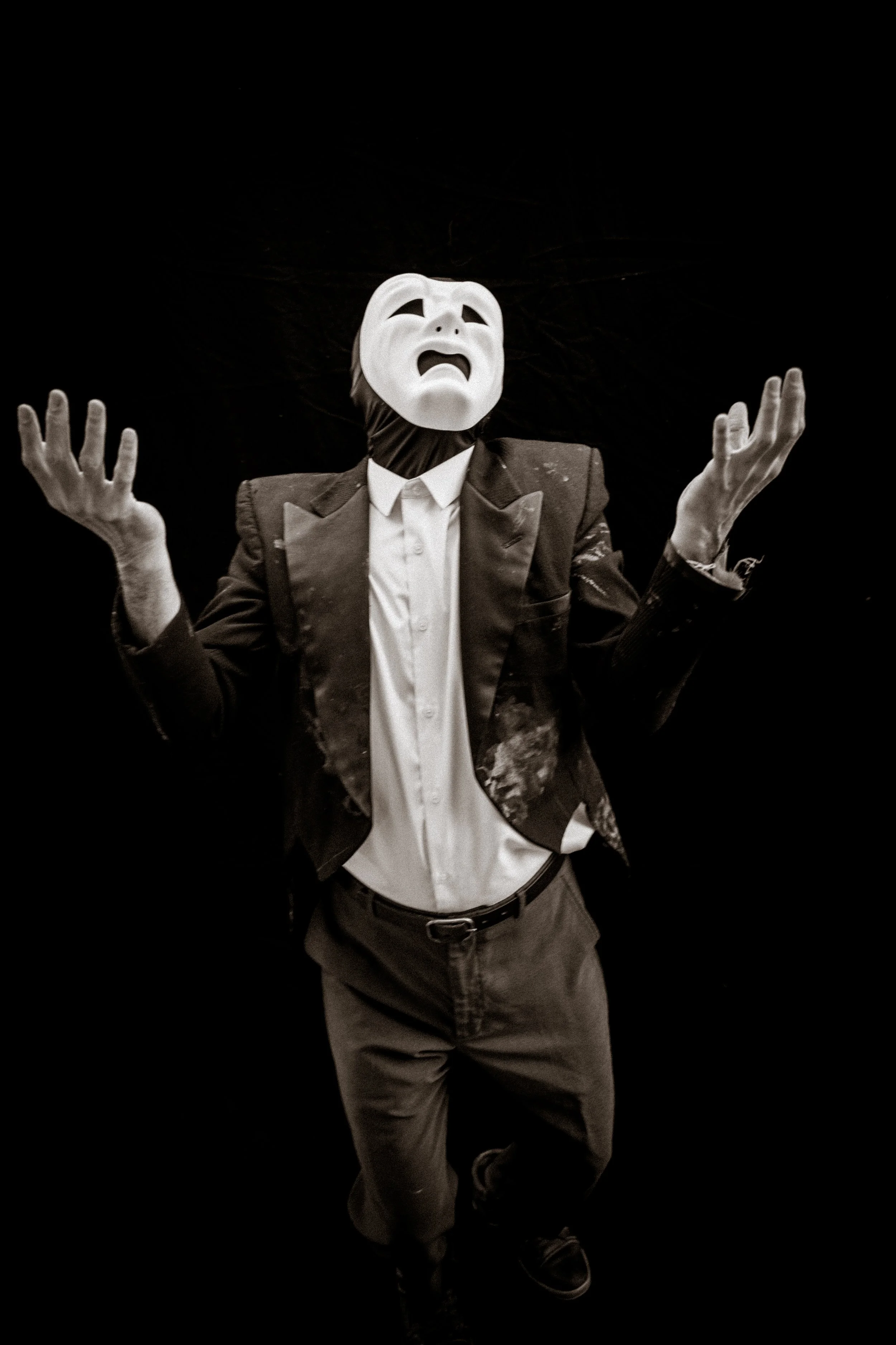 Masked man holds hands out in turmoil.