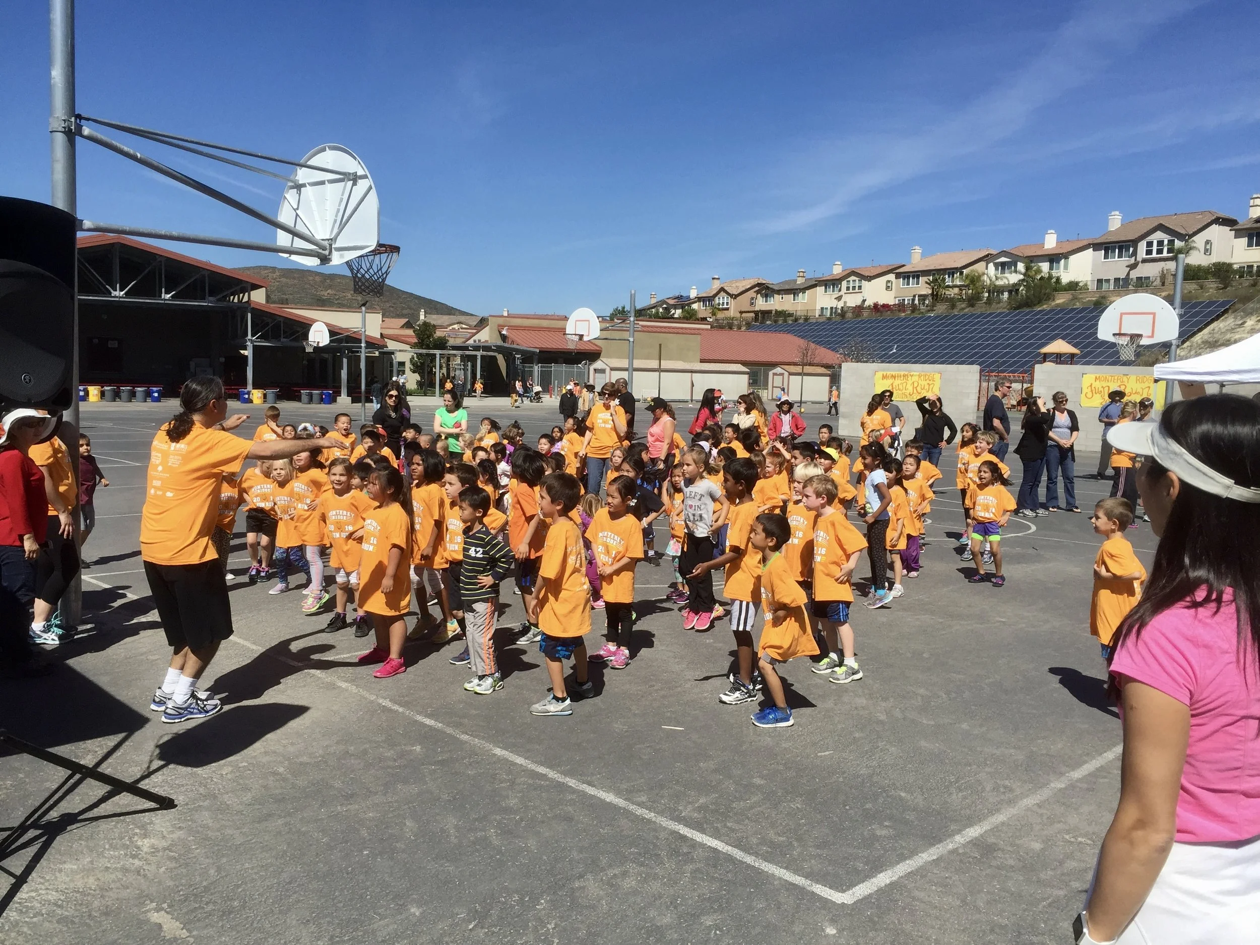 Coach Scott is DJing and leading a Fun Run warm-up at Monterey Ridge Elementary School.