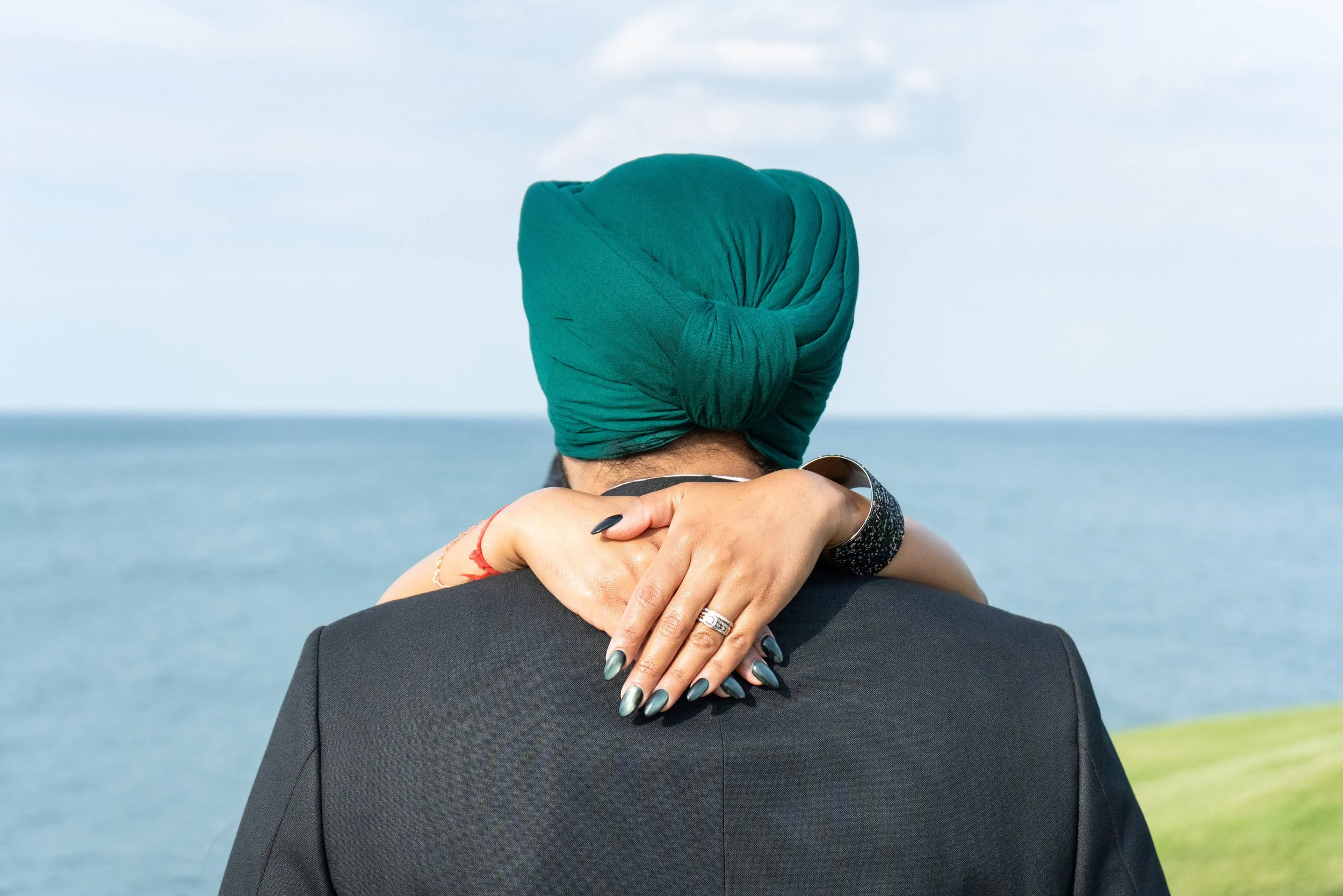 woman resting her arms around her fiances neck to show off the new engagement ring from her surprise proposal at the Lakehouse in the Niagara Region