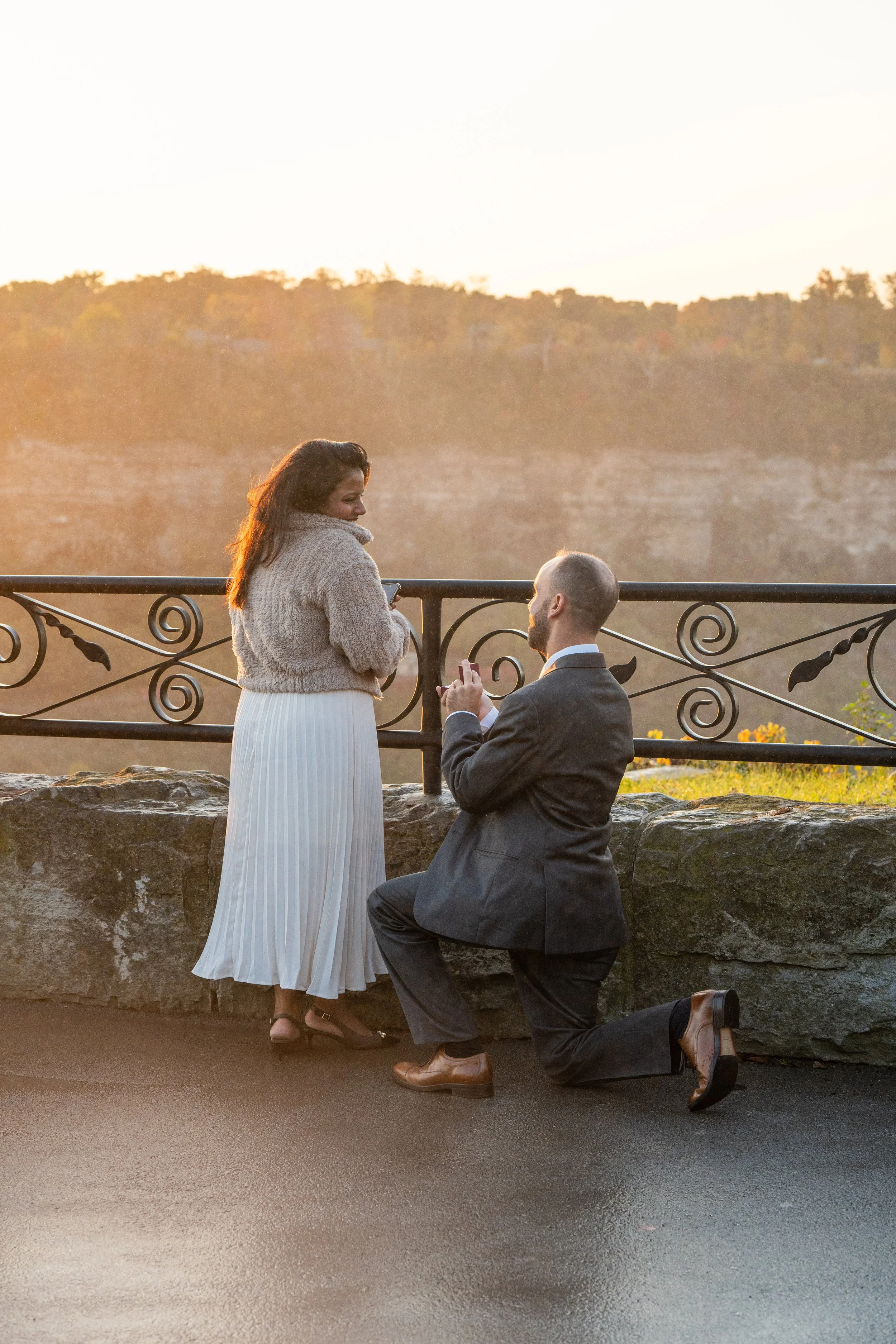 photo of a man proposing to a woman at sunrise overlooking Niagara Falls Ontario