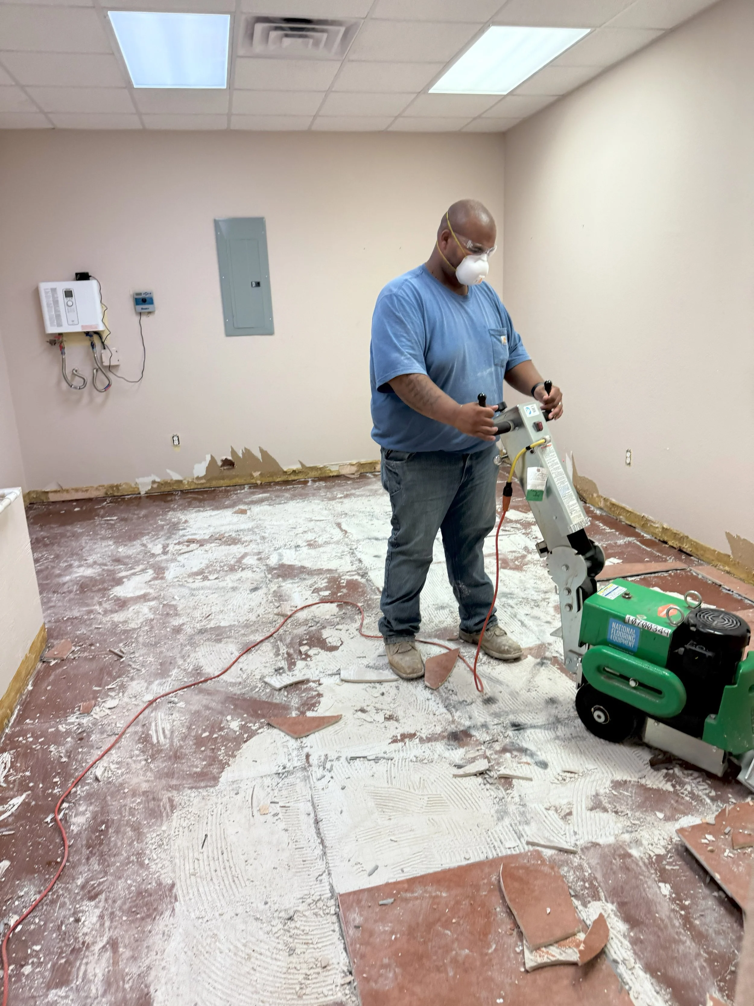 Enviro Medics disaster response and recovery team member removing flooring from a flooded building.