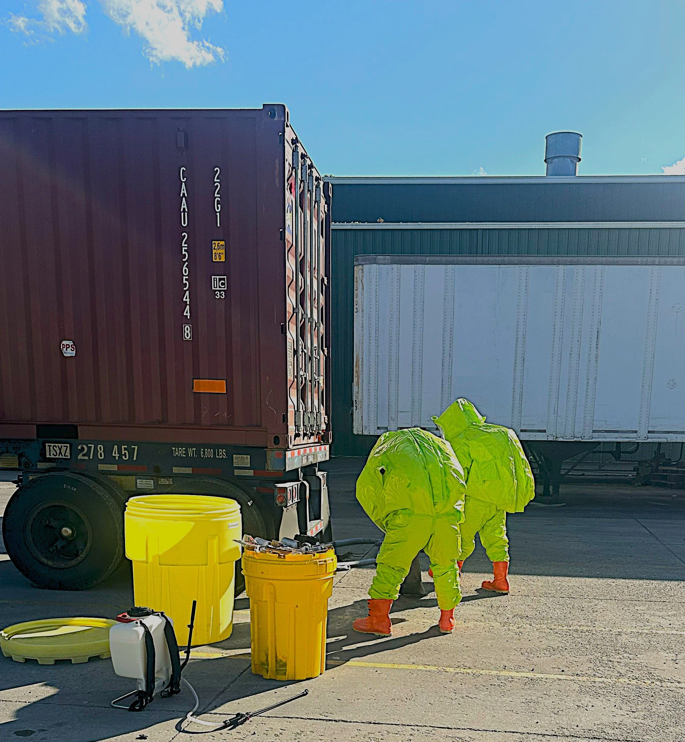 Enviro Medics hazmat technicians in fully encapsulated suits conducting hazardous materials operations at shipping container site in Murfreesboro, Tennessee.