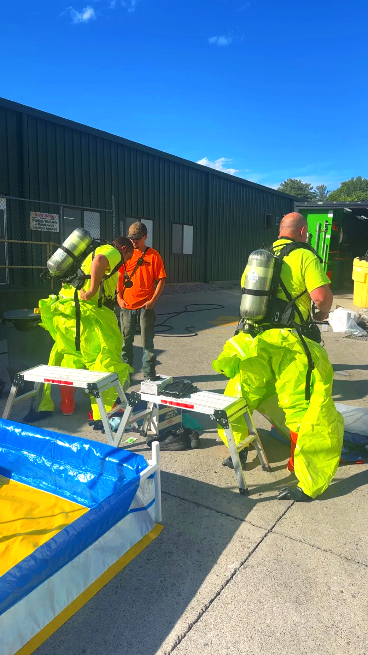 Enviro Medics hazmat technicians donning Level A protective suits and SCBA during hazardous materials incident response in Paris, Tennessee.