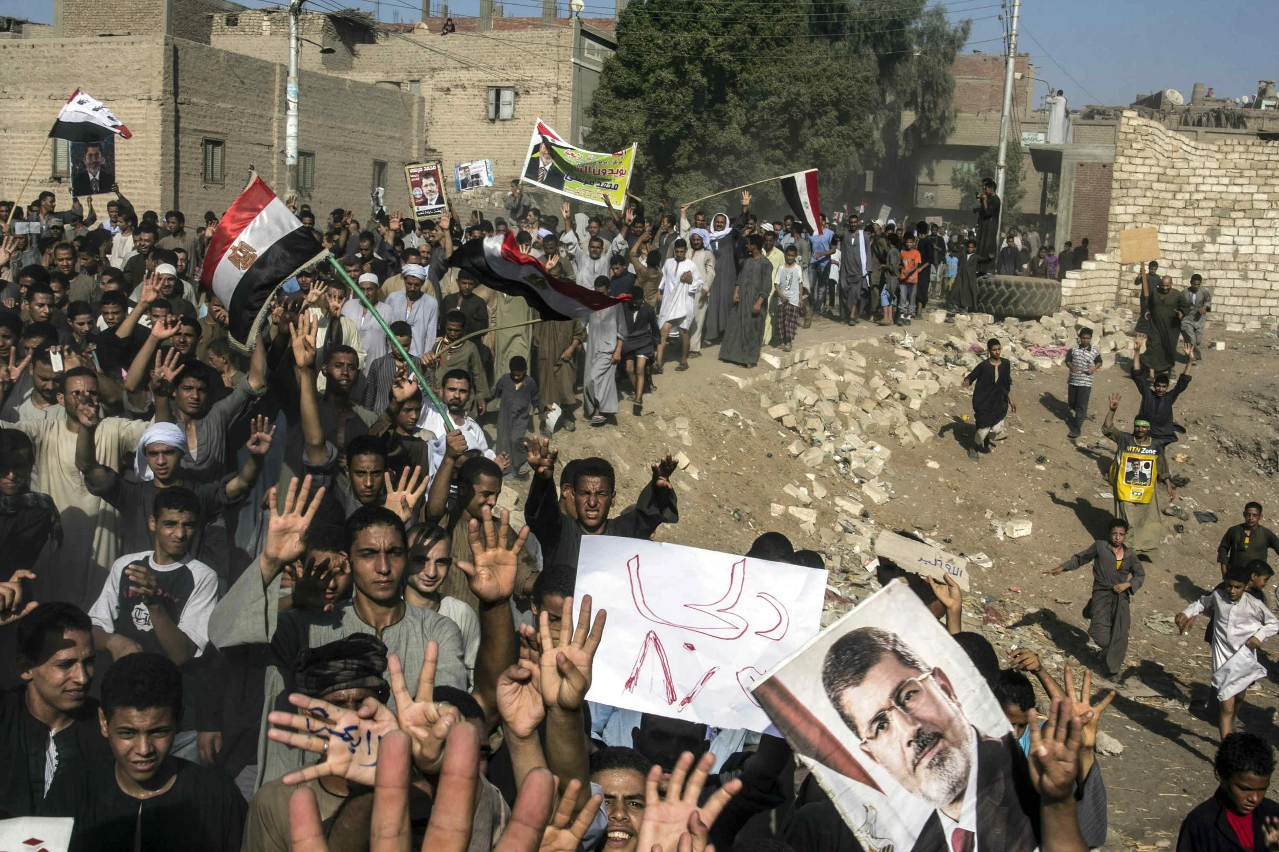 Minya, Aug 2013, Supporters of Egypt's ousted President Mohammed Morsi chant slogans during a demonstration in Dalga, after attacking Christians homes and belongings and destroying their churches in the village.