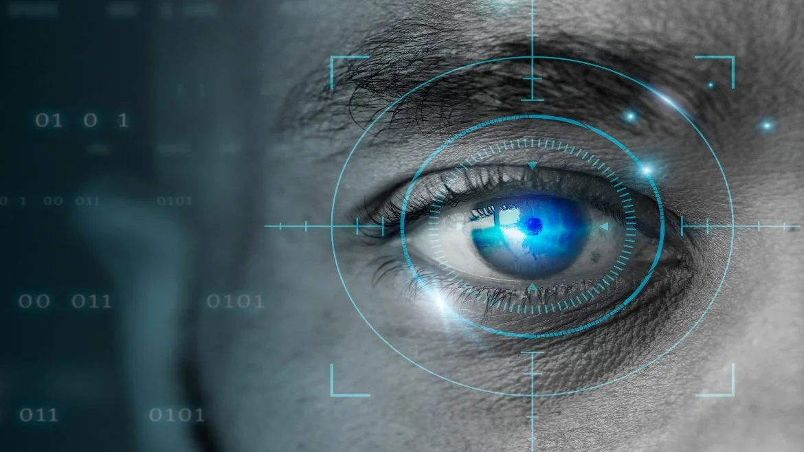 Close-up of a human eye with a digital targeting overlay and blue highlights, indicating biometric or technological analysis.