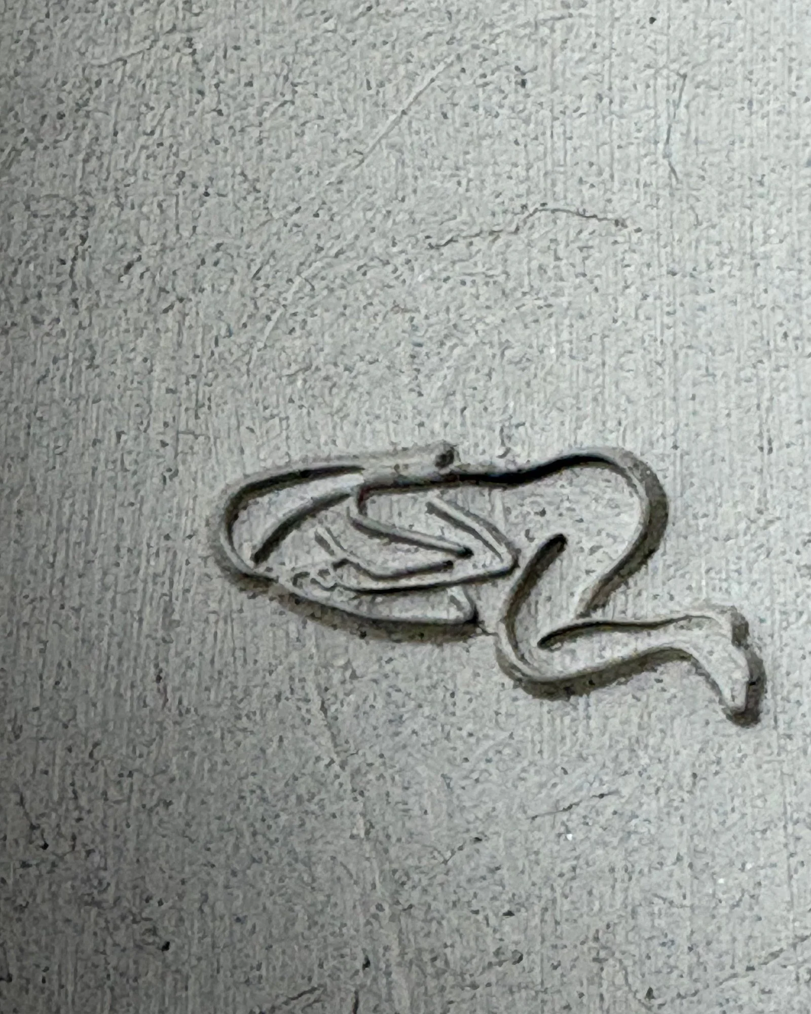 A sleeping figure pressed into a slab of gray clay
